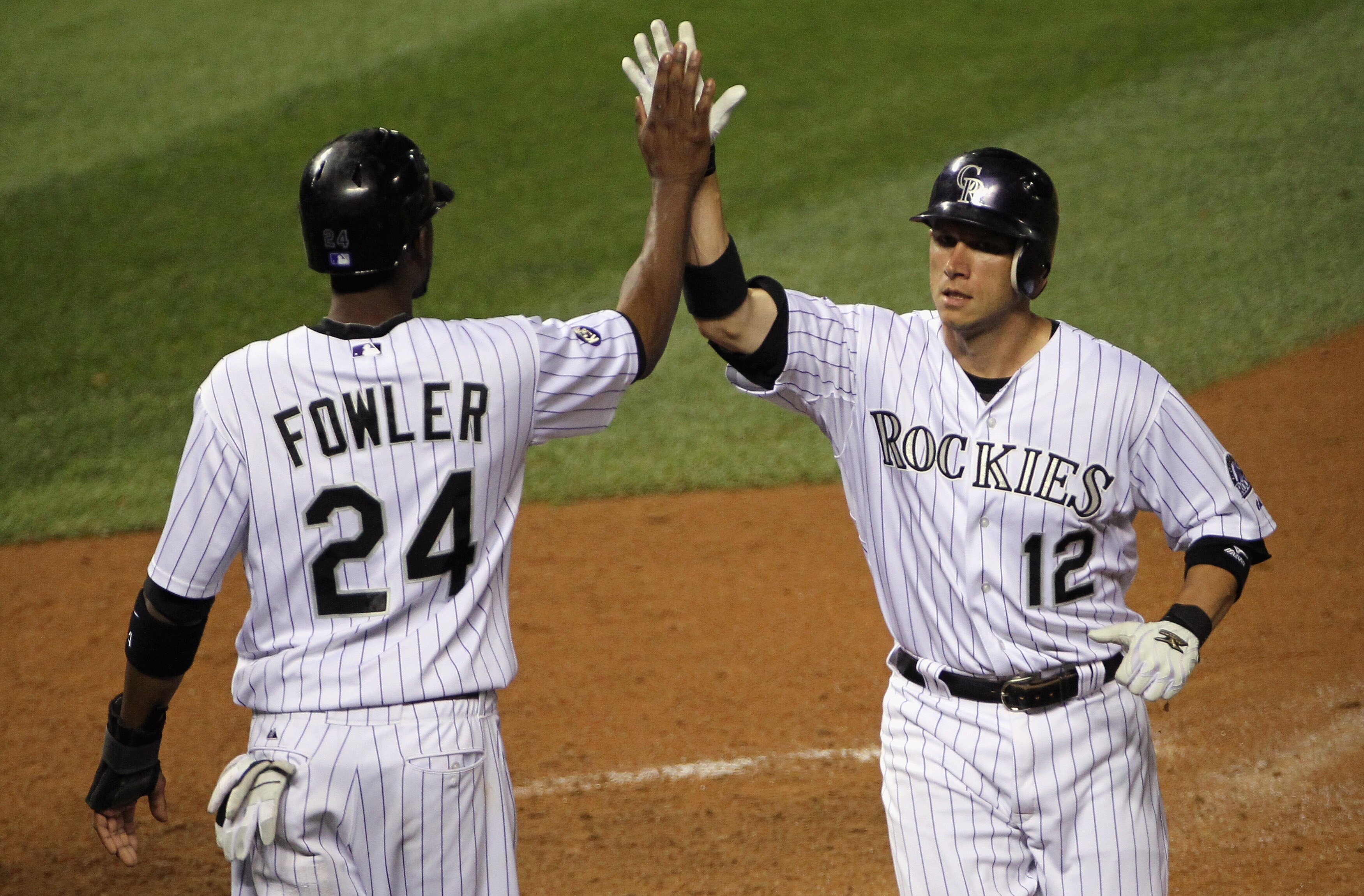 DENVER - SEPTEMBER 25:  Clint Barmes #12 and Dexter Fowler #24 of the Colorado Rockies celebrate after they scored on a double by Troy Tulowitzki to tie the score 9-9 with the San Francisco Giants in the eighth inning at Coors Field on September 25, 2010