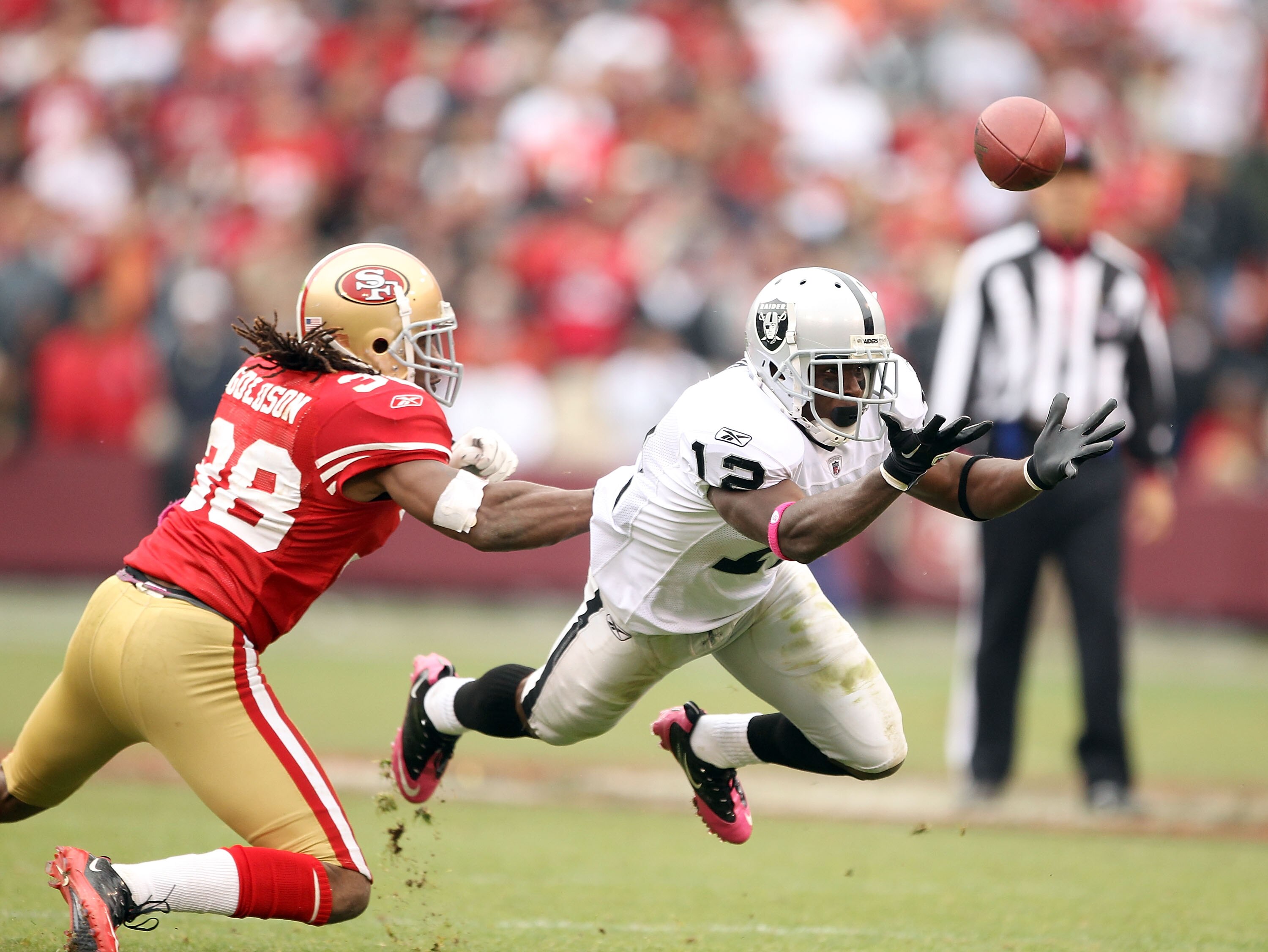 SAN FRANCISCO - OCTOBER 17:  Jacoby Ford #12 of the Oakland Raiders bobbles a ball while defended by Dashon Godson #38 of the San Francisco 49ers at Candlestick Park on October 17, 2010 in San Francisco, California. The ball was intercepted by Takeo Spike