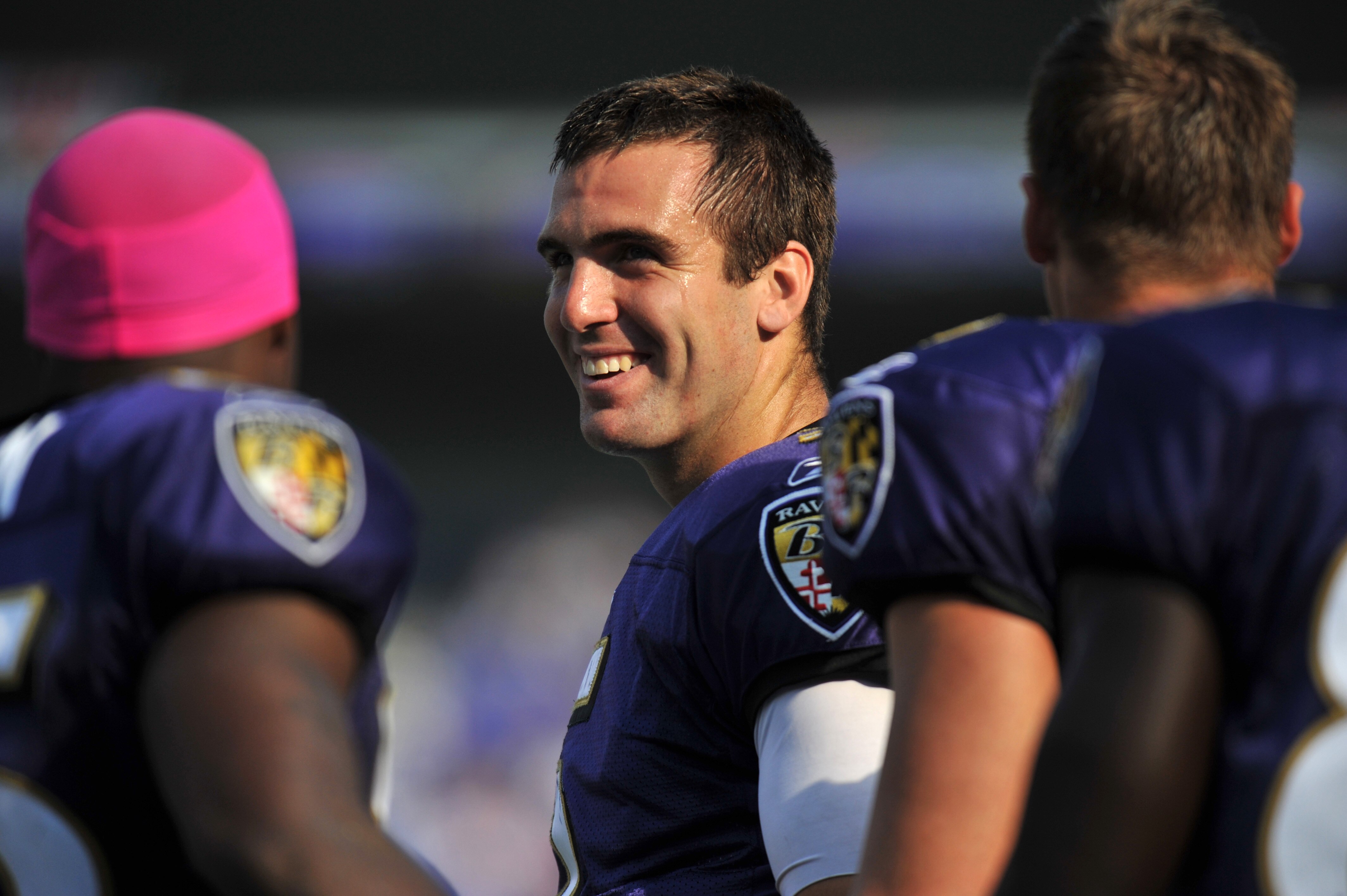 BALTIMORE, MD - OCTOBER 10: Joe Flacco #5 of the Baltimore Ravens smiles on the sidelines during the game against the Denver Broncos at M&T Bank Stadium on October 10, 2010 in Baltimore, Maryland. Players wore pink in recognition of Breast Cancer Awarenes