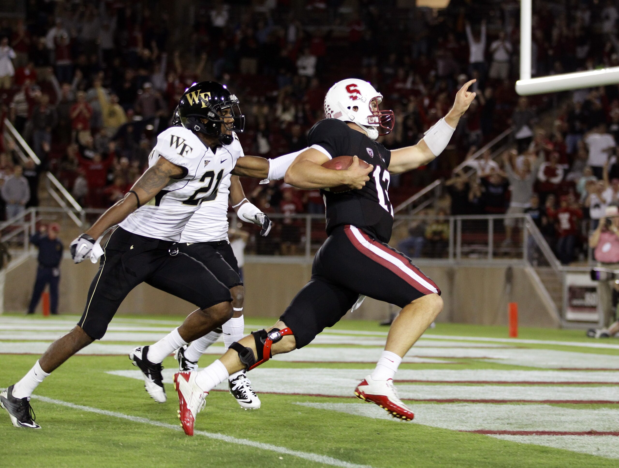 PALO ALTO, CA - SEPTEMBER 18: Andrew Luck #12 of the Stanford Cardinal gets past Alex Frye #21 of the Wake Forest Demon Deacons to score a touchdown at Stanford Stadium on September 18, 2010 in Palo Alto, California. (Photo by Ezra Shaw/Getty Images) PALO ALTO, CA - SEPTEMBER 18: Andrew Luck #12 of the Stanford Cardinal gets past Alex Frye #21 of the Wake Forest Demon Deacons to score a touchdown at Stanford Stadium on September 18, 2010 in Palo Alto, California. (Photo by Ezra Shaw/Getty Images)