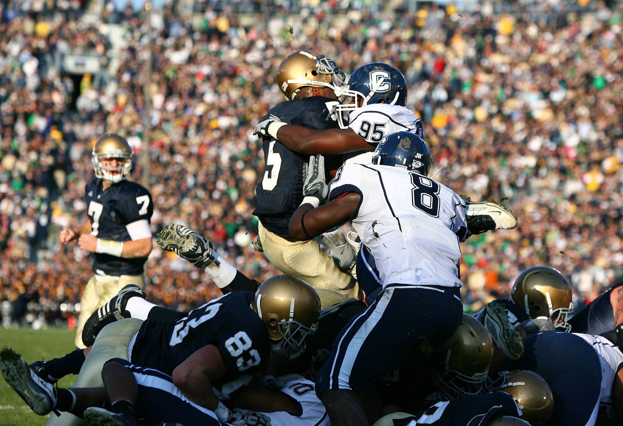SOUTH BEND, IN - NOVEMBER 21: Armando Allen #5 of the Notre Dame Fighting Irish loses his helmet as he is hit at the goal line by Greg Lloyd #95 of the Univeristy of Connecticut Huskies at Notre Dame Stadium on November 21, 2009 in South Bend, Indiana. (P SOUTH BEND, IN - NOVEMBER 21: Armando Allen #5 of the Notre Dame Fighting Irish loses his helmet as he is hit at the goal line by Greg Lloyd #95 of the Univeristy of Connecticut Huskies at Notre Dame Stadium on November 21, 2009 in South Bend, Indiana. (P