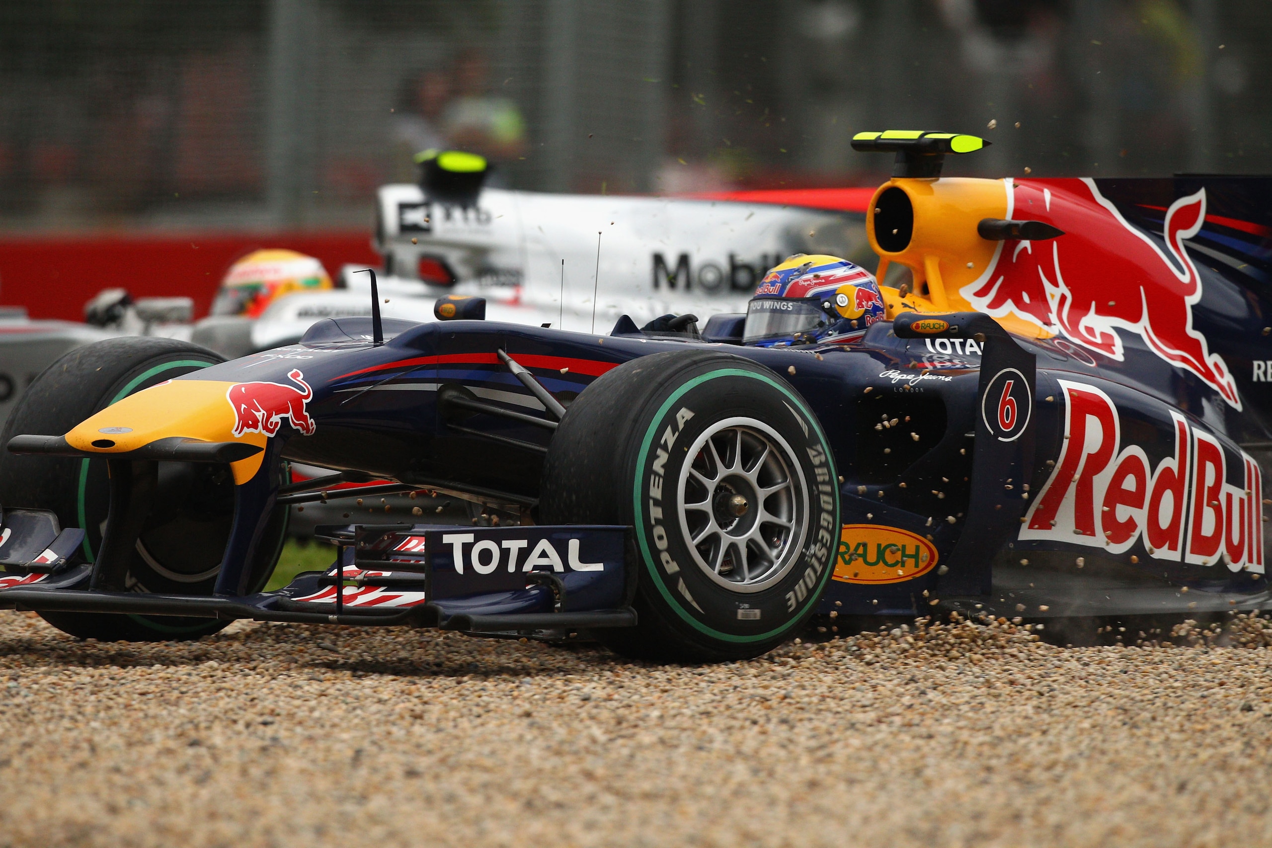 MELBOURNE, AUSTRALIA - MARCH 28:  Mark Webber of Australia and Red Bull Racing runs off into the gravel as Lewis Hamilton of Great Britain and McLaren Mercedes passes him during Australian Formula One Grand Prix at the Albert Park Circuit on March 28, 201
