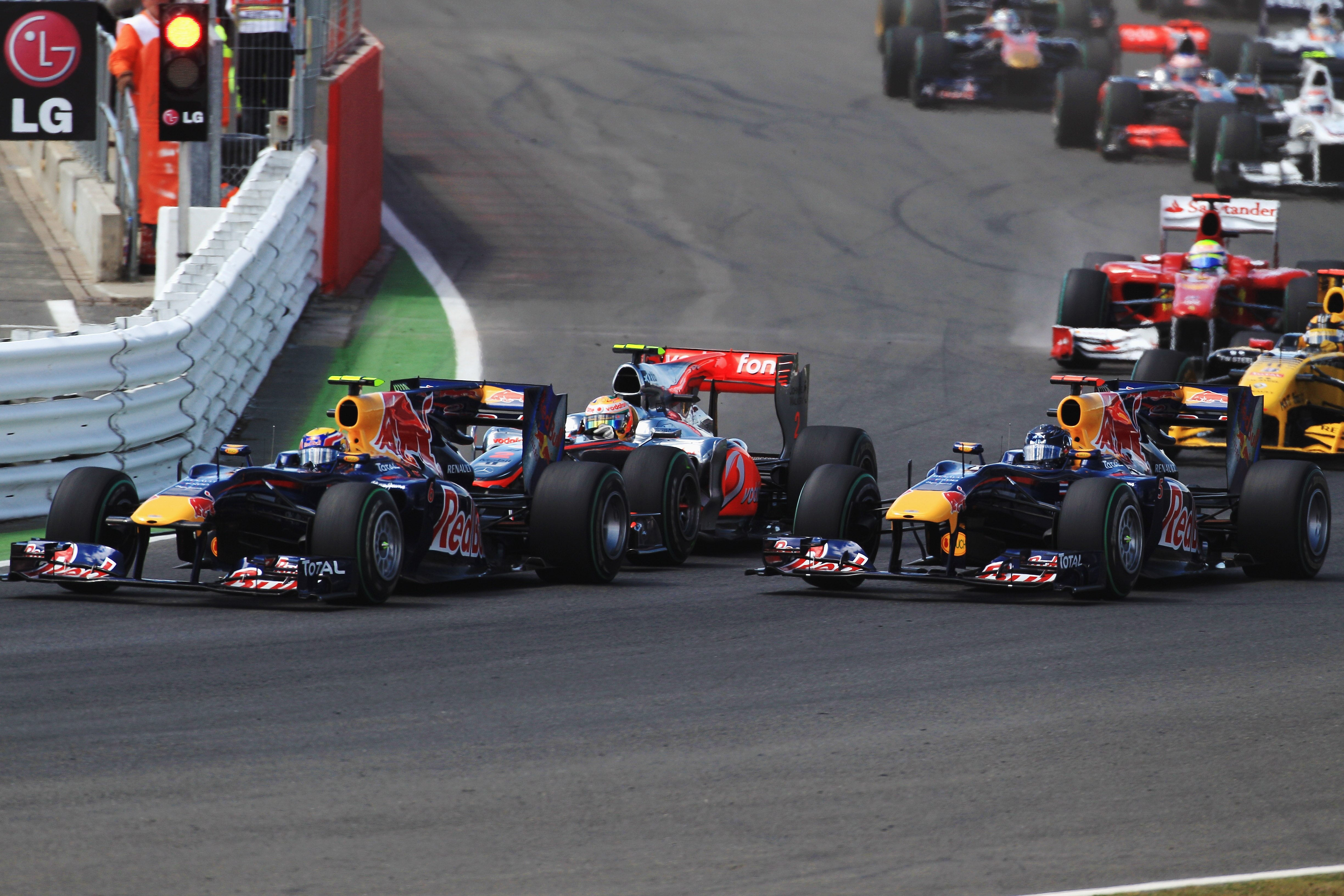 NORTHAMPTON, UNITED KINGDOM - JULY 11:  Mark Webber (L) of Australia and Red Bull Racing, Lewis Hamilton (C) of Great Britain and McLaren Mercedes and Sebastian Vettel (R) of Germany and Red Bull Racing drive side by side thru the first corner at the star