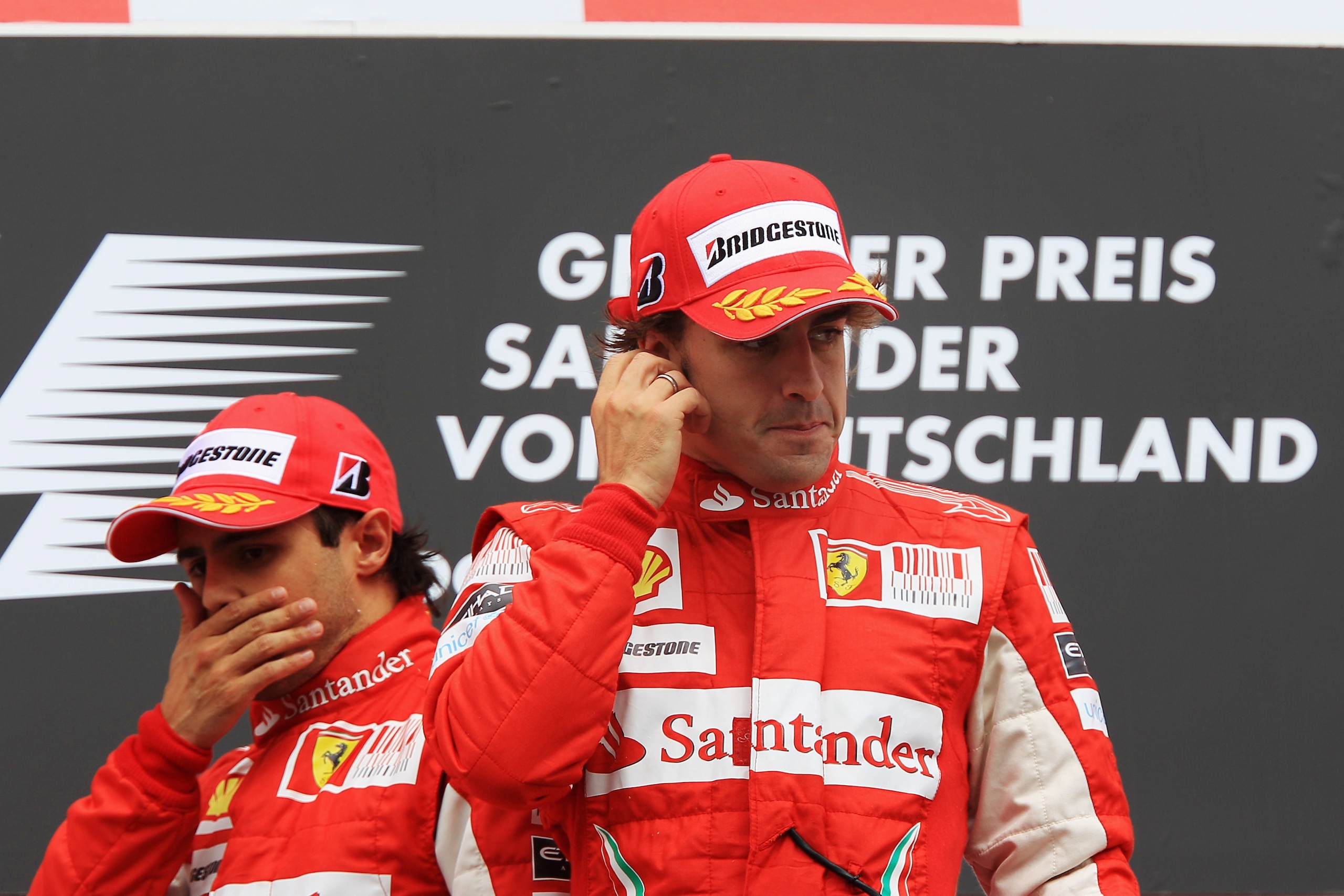 HOCKENHEIM, GERMANY - JULY 25:  Race winner Fernando Alonso (R) of Spain and Ferrari celebrates on the podium with second placed Felipe Massa (L) of Brazil and Ferrari following the German Grand Prix at Hockenheimring on July 25, 2010 in Hockenheim, Germa