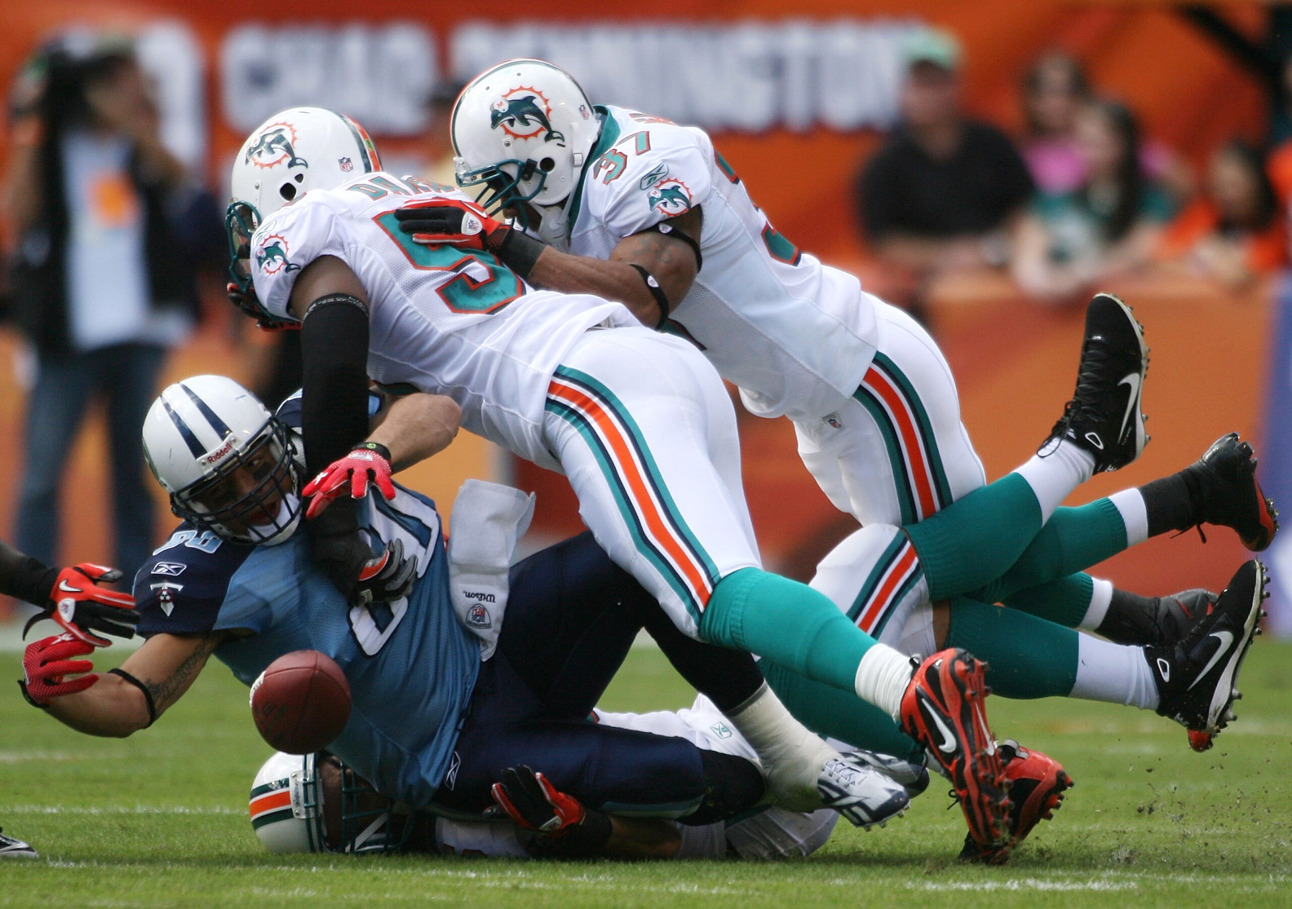 MIAMI - NOVEMBER 14:  Tight end Bo Scaife #80 of the Tennessee Titans fumbles against defenders Karlos Dansby and Yeramiah Bell #37 of the Miami Dolphins at Sun Life Stadium on November 14, 2010 in Miami, Florida.  (Photo by Marc Serota/Getty Images)