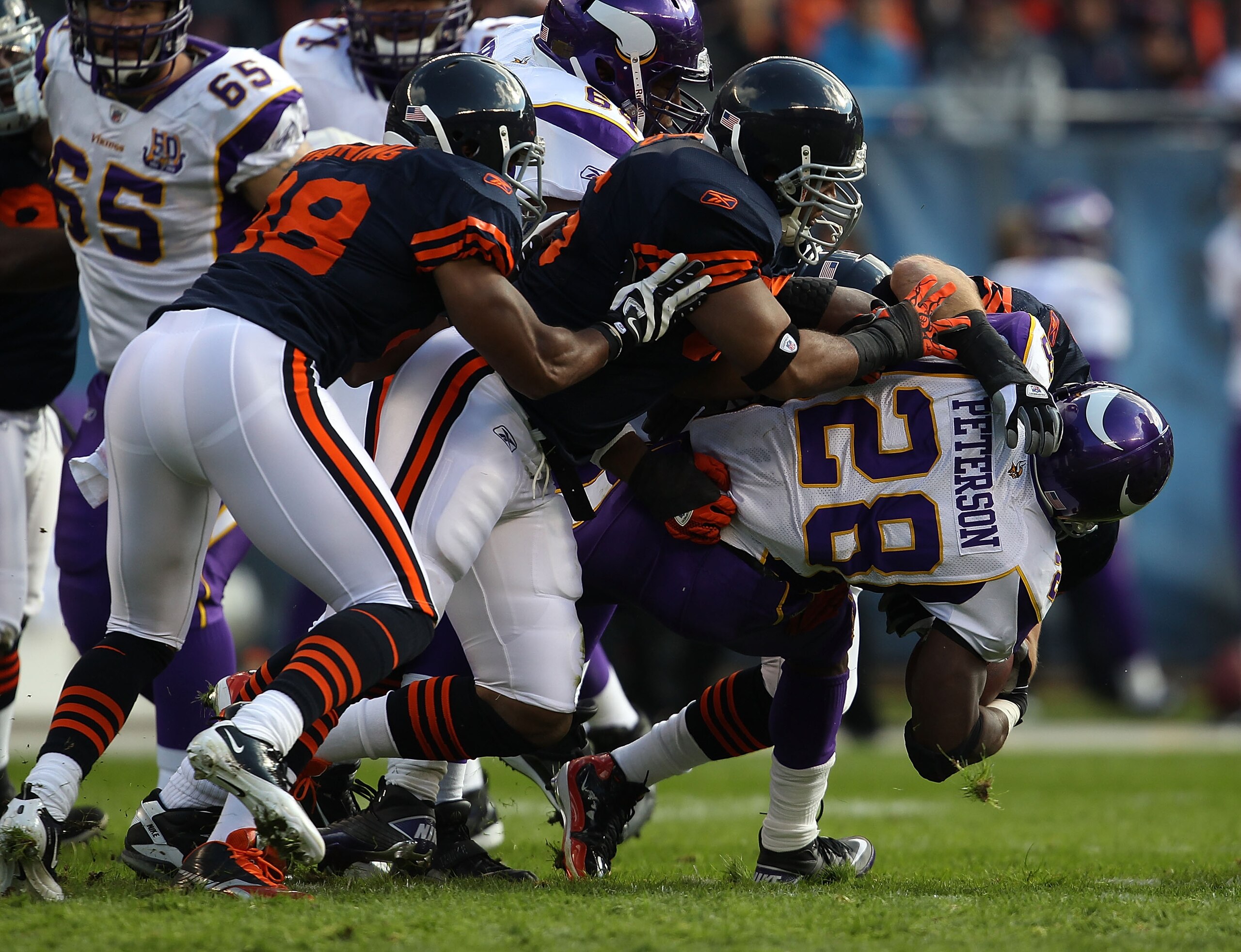 CHICAGO - NOVEMBER 14: (L-R) Rod Wilson #58, Lance Briggs #55 and Brian Urlacher #54 of the Chicago Bears tackle Adrian Peterson #28 of the Minnesota Vikings at Soldier Field on November 14, 2010 in Chicago, Illinois. The Bears defeated the Packers 27-13.
