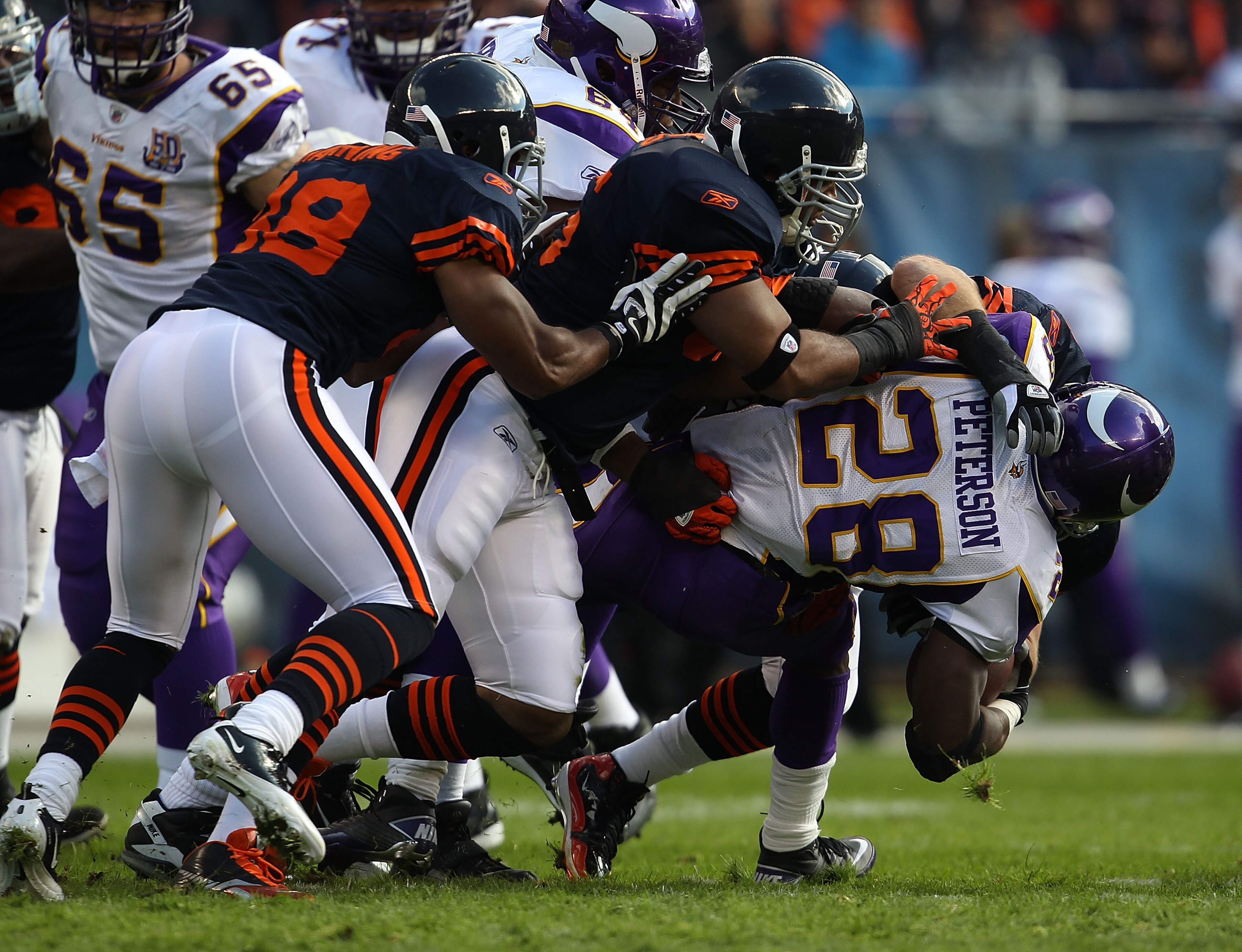 CHICAGO - NOVEMBER 14: (L-R) Rod Wilson #58, Lance Briggs #55 and Brian Urlacher #54 of the Chicago Bears tackle Adrian Peterson #28 of the Minnesota Vikings at Soldier Field on November 14, 2010 in Chicago, Illinois. The Bears defeated the Packers 27-13.