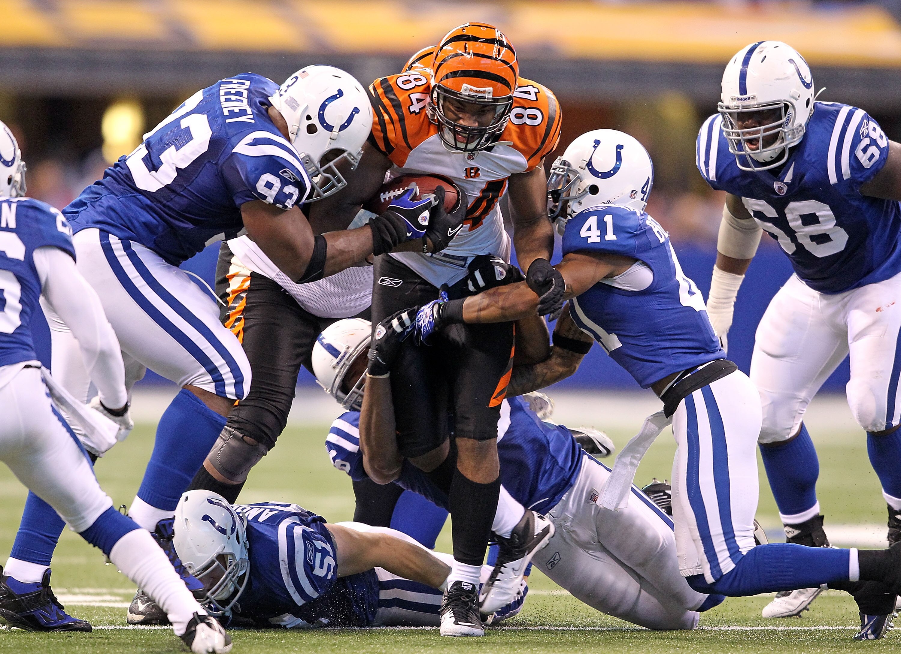 INDIANAPOLIS - NOVEMBER 14:  Jermaine Gresham #84 of the Cincinnati Bengals runs with the ball after catching and is tackled by Dwight Freeney #91 and Antoine Bethea #41 of the Indianapolis Colts in the NFL game at Lucas Oil Stadium on November 14, 2010 i