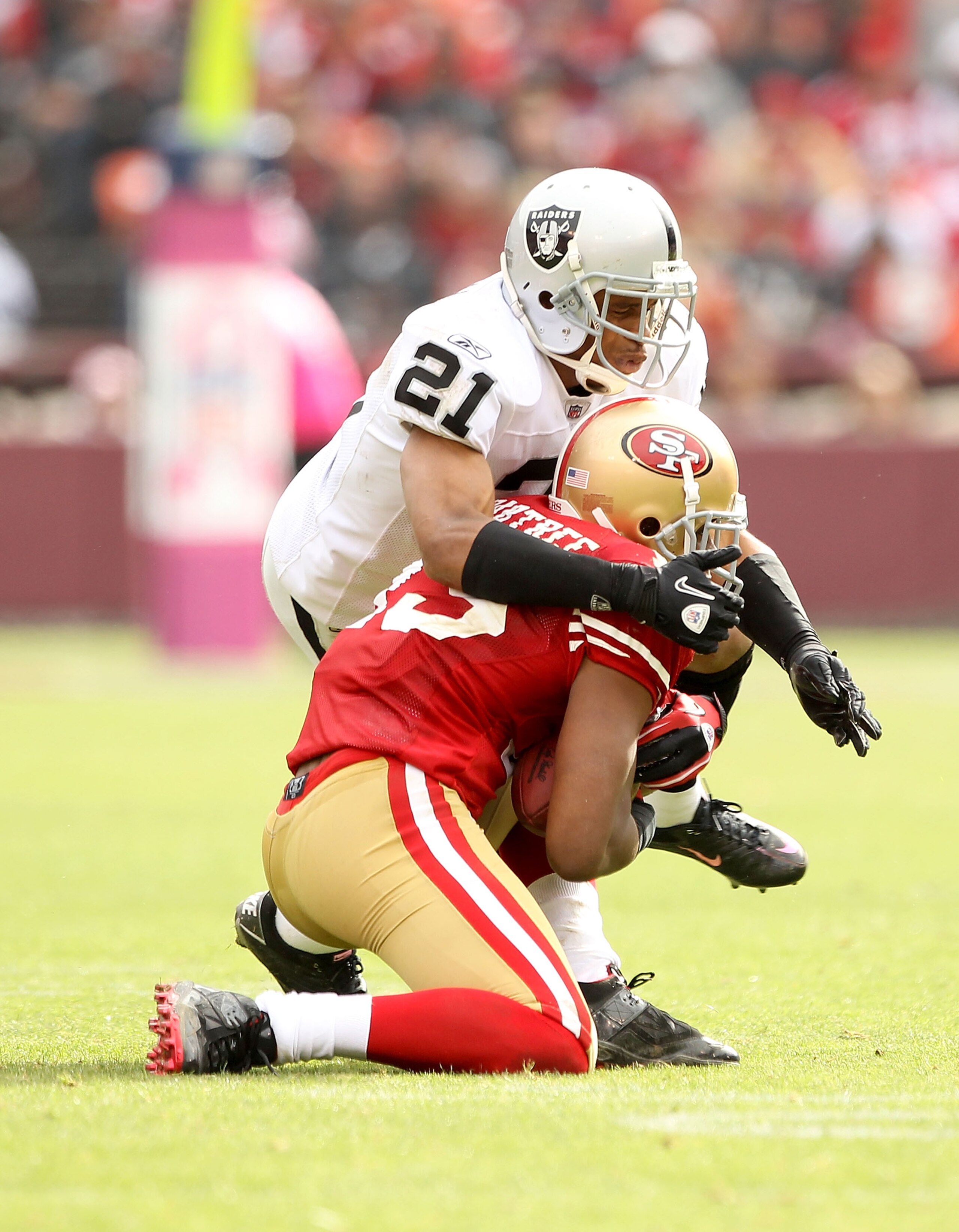 SAN FRANCISCO - OCTOBER 17:  Nnamdi Asomugha #21 of the Oakland Raiders tackles Michael Crabtree #15 of the San Francisco 49ers at Candlestick Park on October 17, 2010 in San Francisco, California.  (Photo by Ezra Shaw/Getty Images)