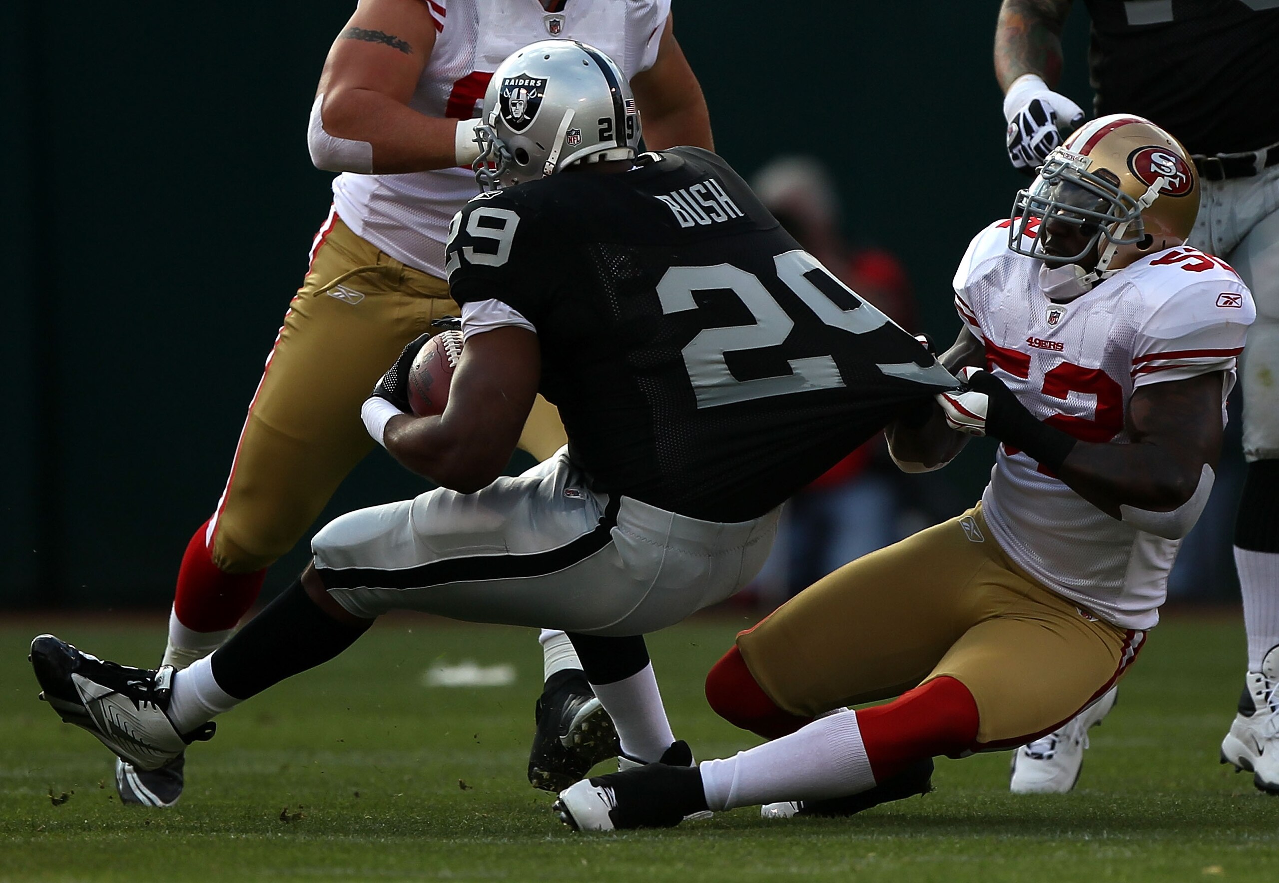 OAKLAND, CA - AUGUST 28:  Patrick Willis #52 of the San Francisco 49ers stops Michael Bush #20 of the Oakland Raiders during an NFL preseason game at Oakland-Alameda County Coliseum on August 28, 2010 in Oakland, California.  (Photo by Jed Jacobsohn/Getty