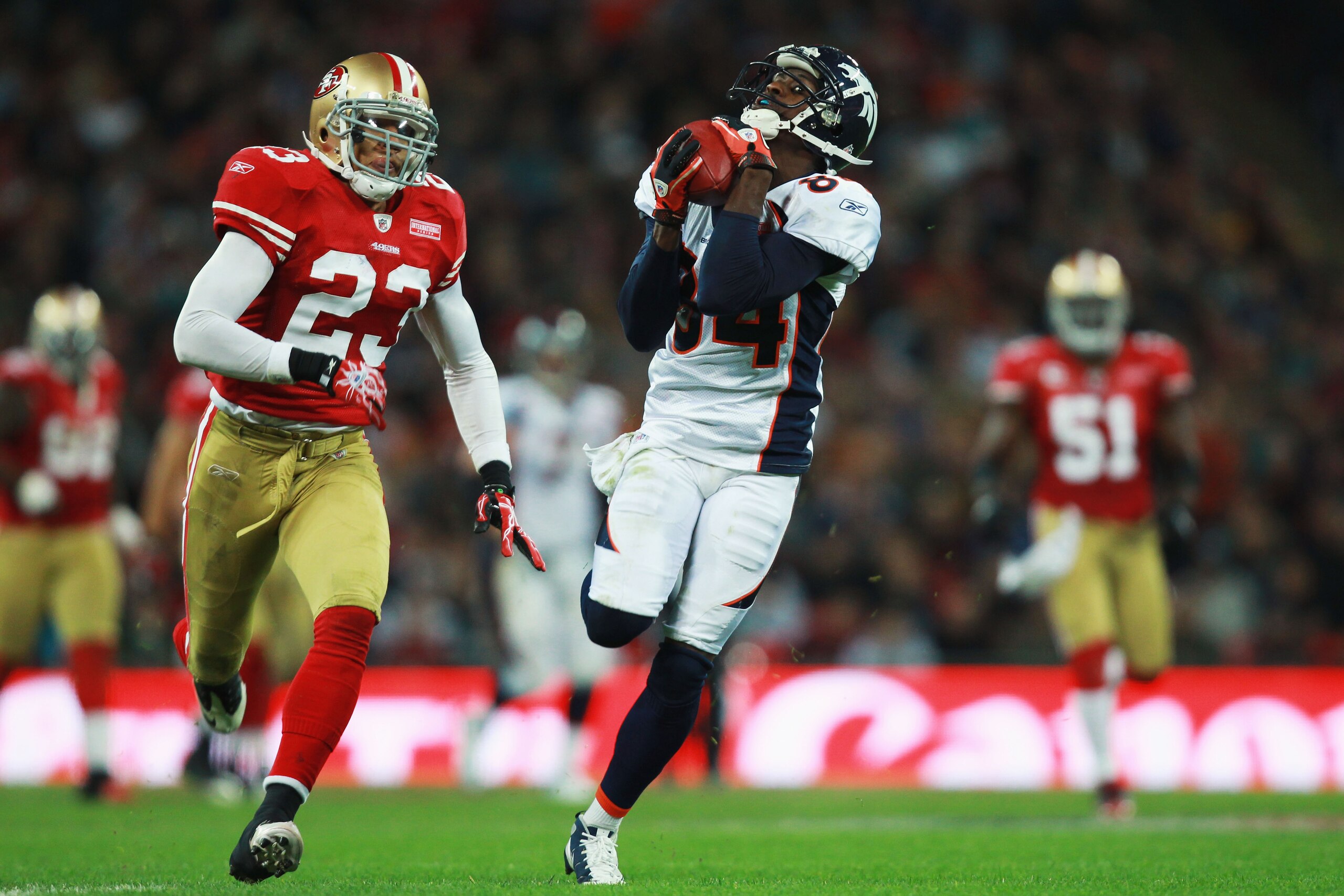LONDON, ENGLAND - OCTOBER 31:  Brandon Lloyd #84 of Denver Broncos catches the ball ahead of Taylor Mays #23 of San Francisco 49ers during the NFL International Series match between Denver Broncos and San Francisco 49ers at Wembley Stadium on October 31,