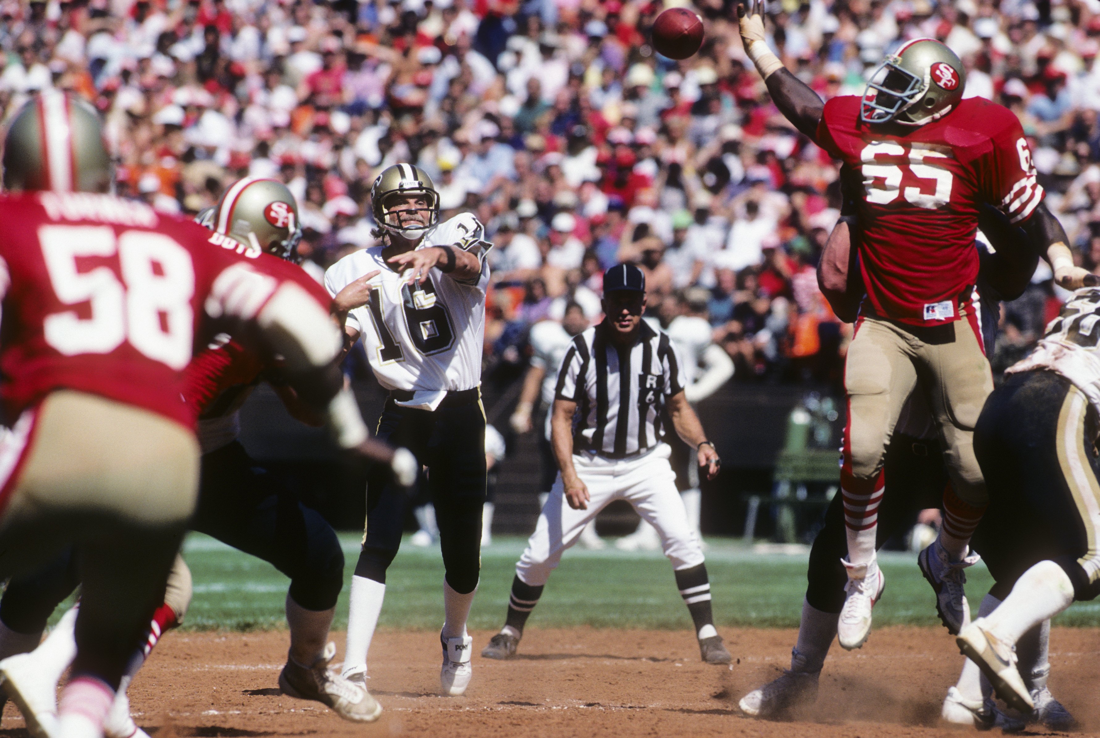 SAN FRANCISCO - SEPTEMBER 16:  Defenive end Lawrence Pillers #65 of the San Francisco 49ers attempts to bat down a pass thrown by quarterback Ken Stabler #16 of the New Orleans Saints as NFL referee Tom Dooley #6 watches the action during a game at Candle