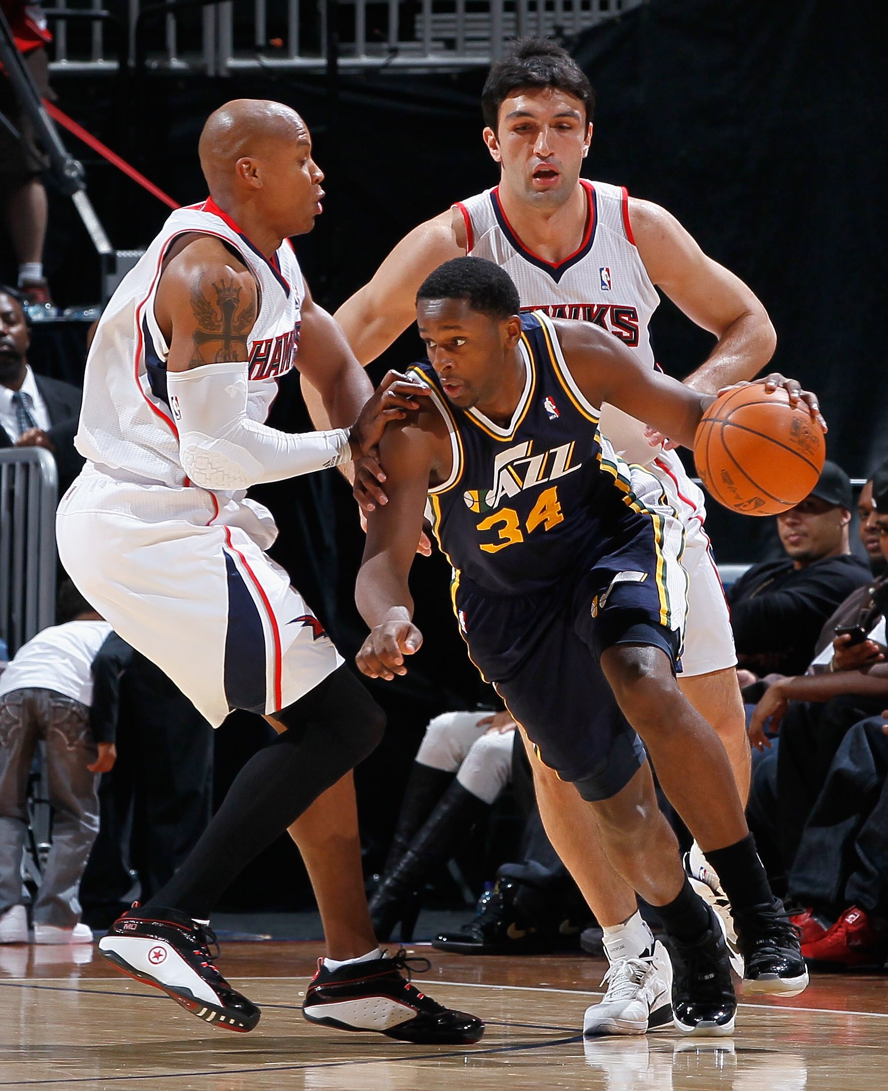 ATLANTA - NOVEMBER 12:  C.J. Miles #34 of the Utah Jazz drives around Maurice Evans #1 and Zaza Pachulia #27 of the Atlanta Hawks at Philips Arena on November 12, 2010 in Atlanta, Georgia.  NOTE TO USER: User expressly acknowledges and agrees that, by dow