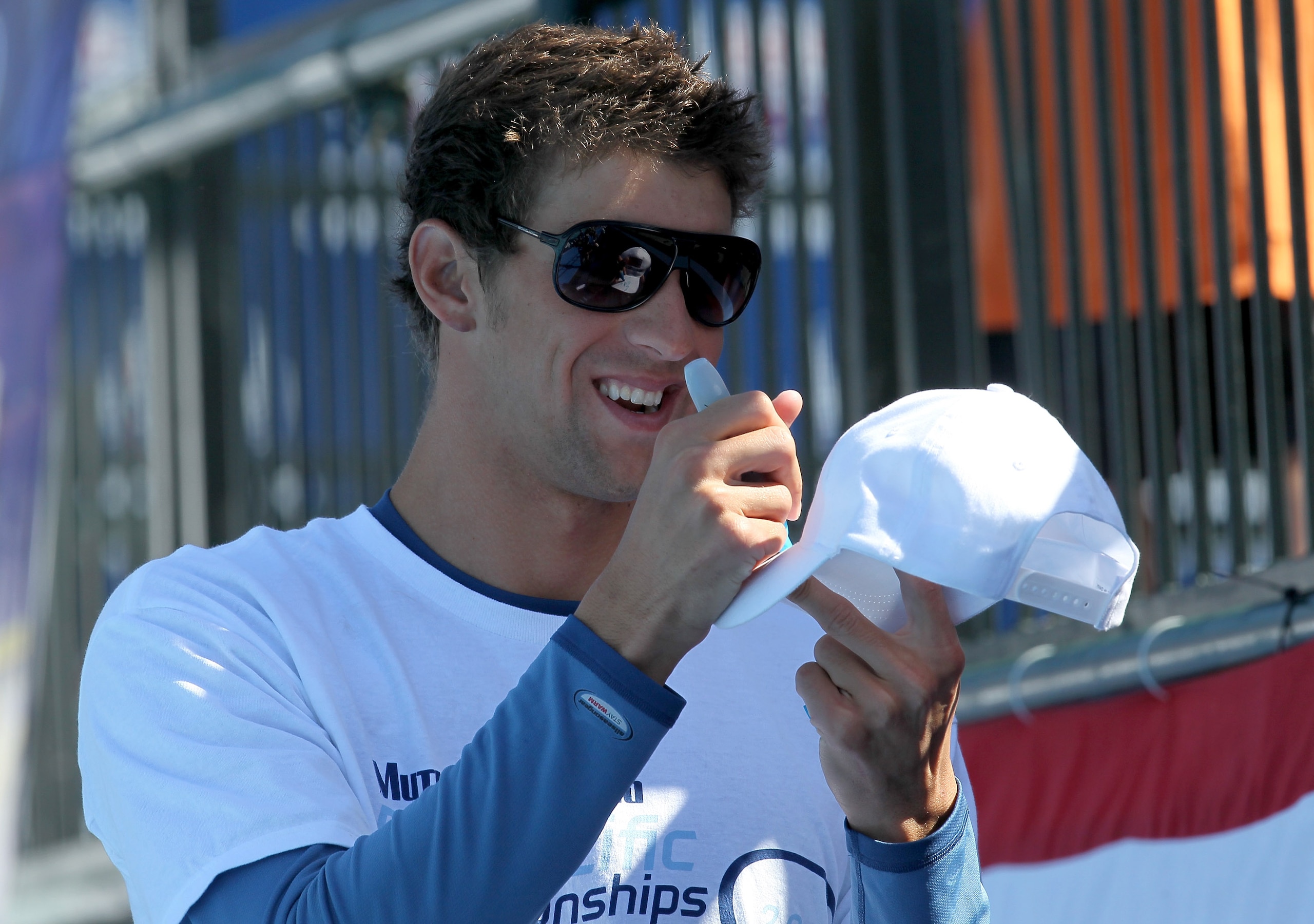 IRVINE, CA - AUGUST 21:  Michael Phelps signs an autograph during qualifying heats during the Mutual of Omaha Pan Pacific Championships at the William Woollett Jr. Aquatic Center on August 21, 2010 in Irvine, California.  (Photo by Stephen Dunn/Getty Imag