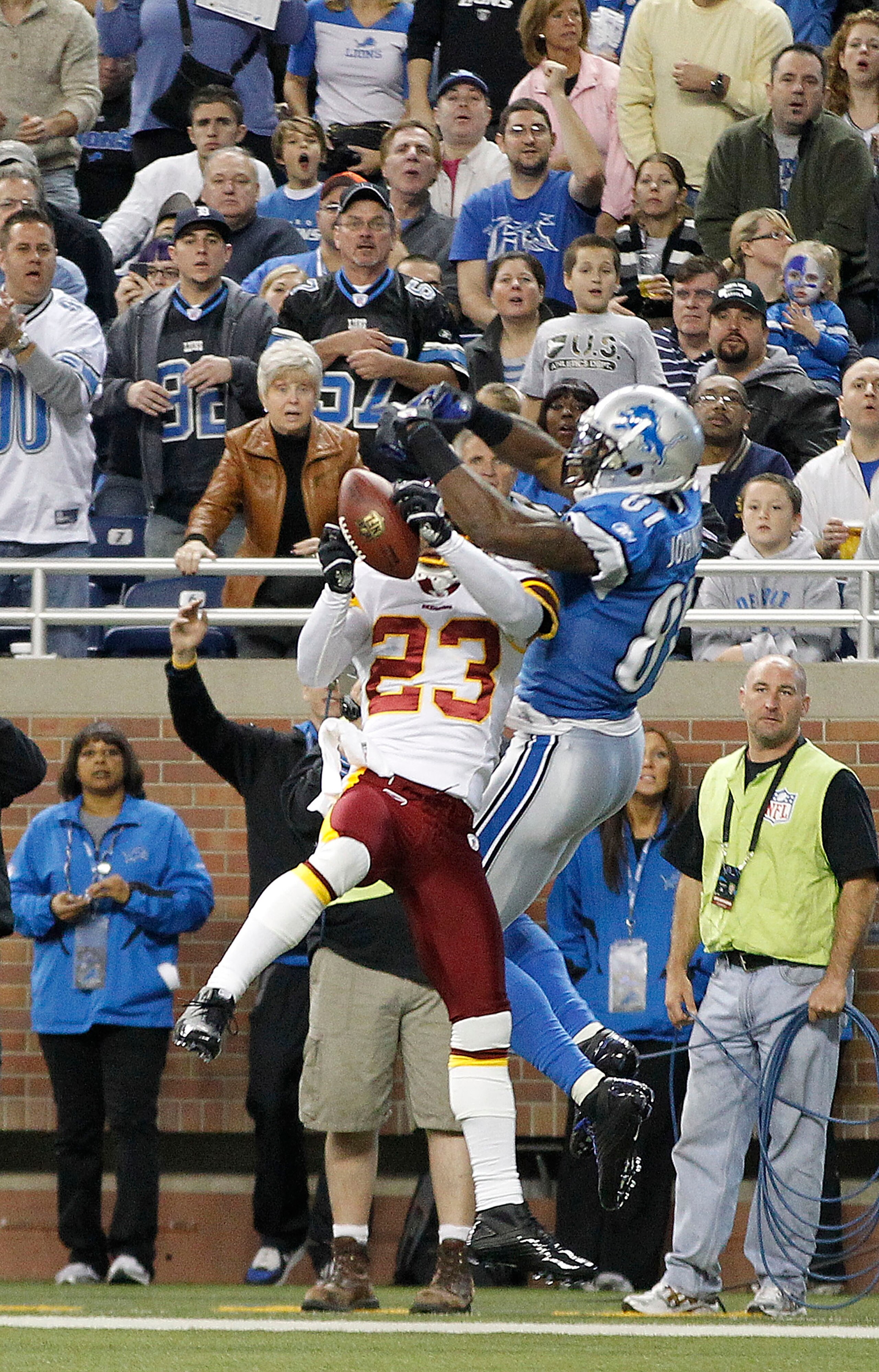 DETROIT - OCTOBER 31: DeAngelo Hall #23 of the Washingon Redskins intercepts the pass during the second quarter as Calvin Johnson #81 of the Detroit Lions atempts to defend during the game at Ford Field on October 31, 2010 in Detroit, Michigan.  (Photo by