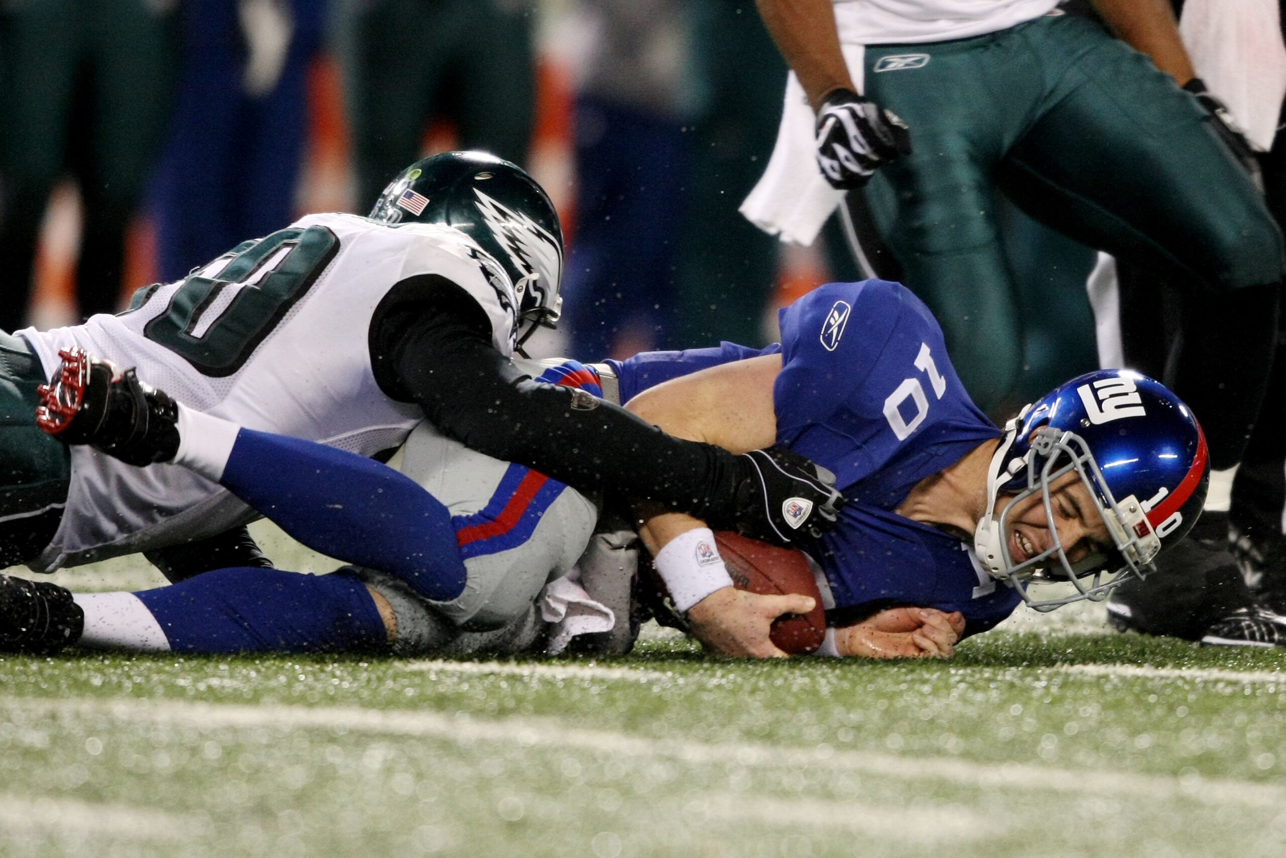 EAST RUTHERFORD, NJ - DECEMBER 13:  Eli Manning #10 of the New York Giants is sacked by a member of the Philadelphia Eagles at Giants Stadium on December 13, 2009 in East Rutherford, New Jersey.  (Photo by Nick Laham/Getty Images)