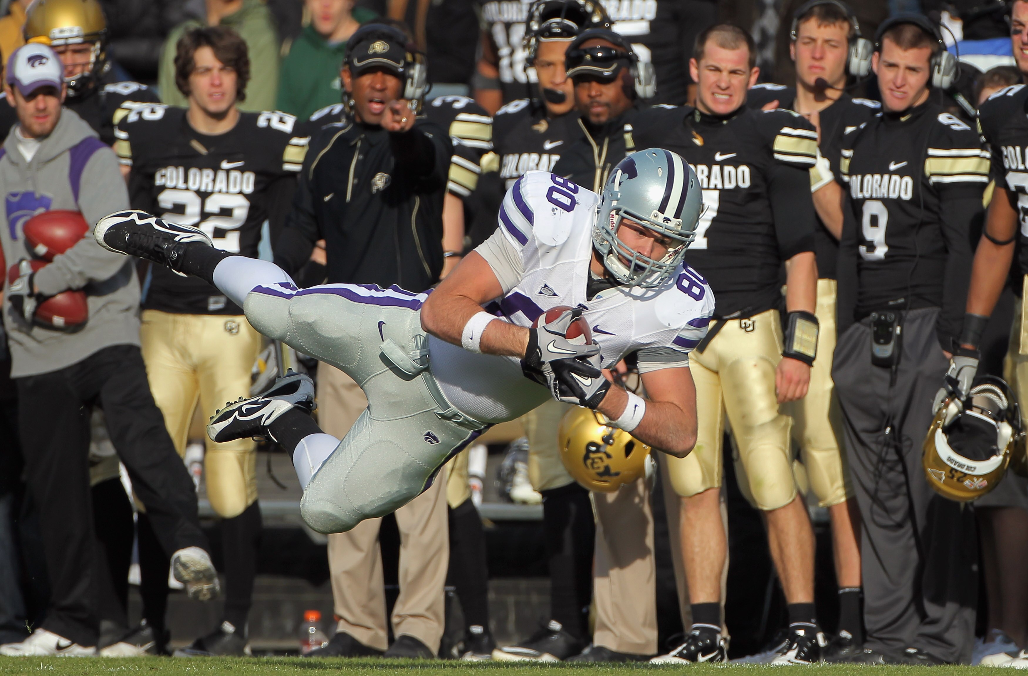 BOULDER, CO - NOVEMBER 20:  Tight end Travis Tannahill #80 of the Kansas State Wildcats dives to catch a 24 yard pass from quarterback Carson Coffman for a first down as the Colorado Buffaloes bench reacts at Folsom Field on November 20, 2010 in Boulder, 