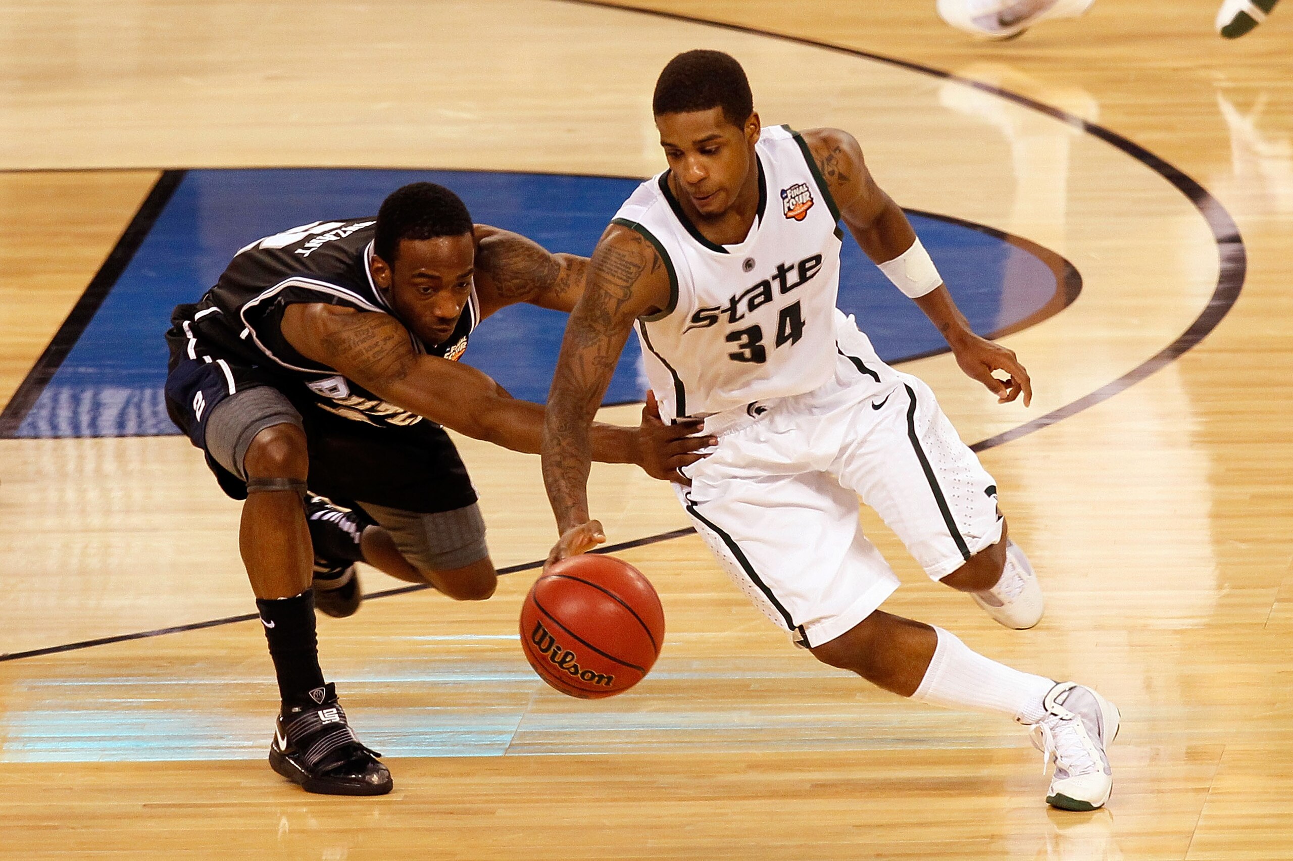 INDIANAPOLIS - APRIL 03:  Korie Lucious #34 of the Michigan State Spartans moves the ball as Shawn Vanzant #2 of the Butler Bulldogs goes for a steal during the National Semifinal game of the 2010 NCAA Division I Men's Basketball Championship on April 3,