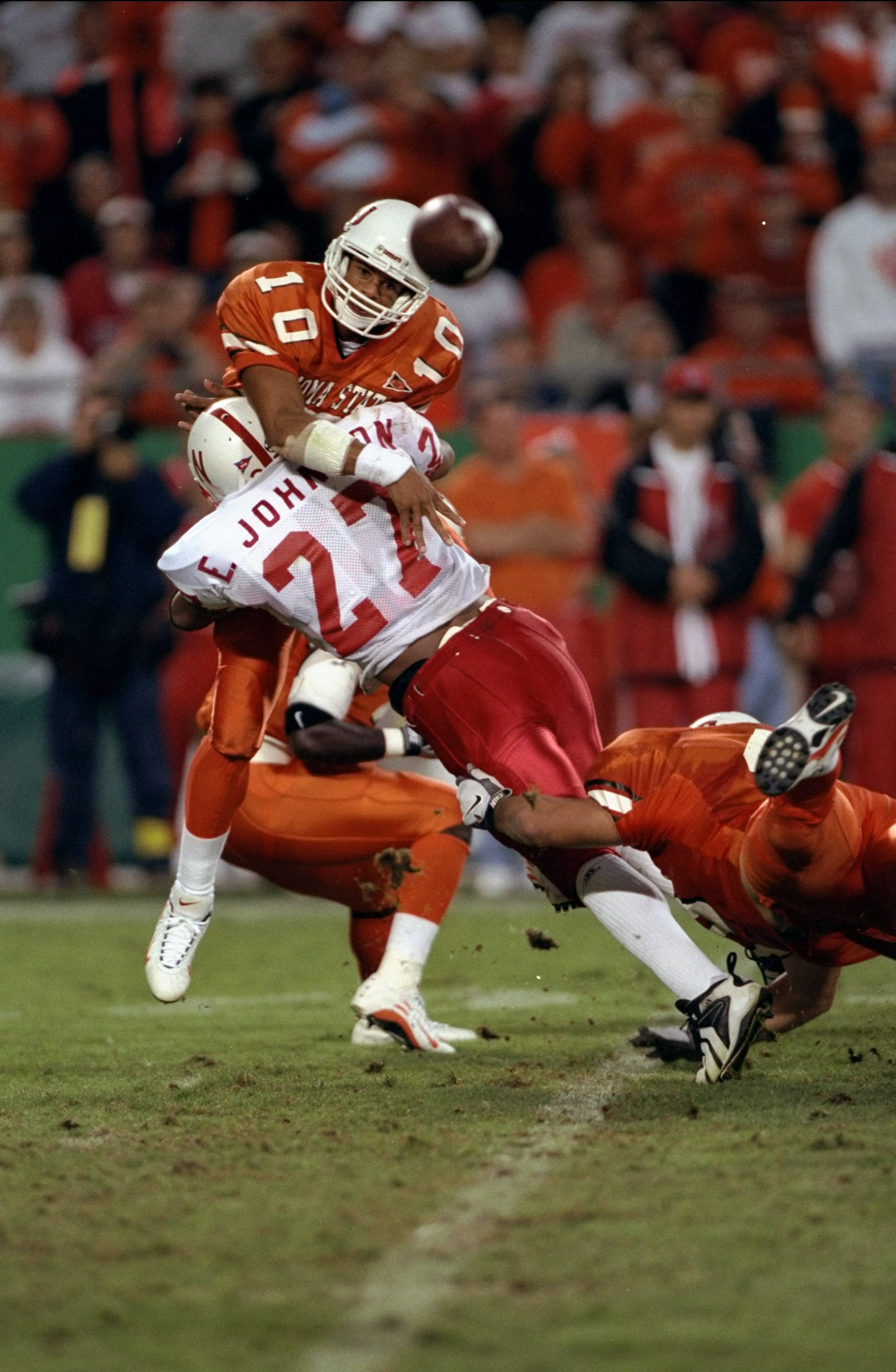 3 Oct 1998:  Quarterback Tony Lindsay #10 of the Oklahoma State Cowboys throws the ball before being tackled by Eric Johnson #27 of the Nebraska Cornhuskers during a game at the Arrowhead Stadium in Kansas City, Missouri. The Cornhuskers defeated the Cowb