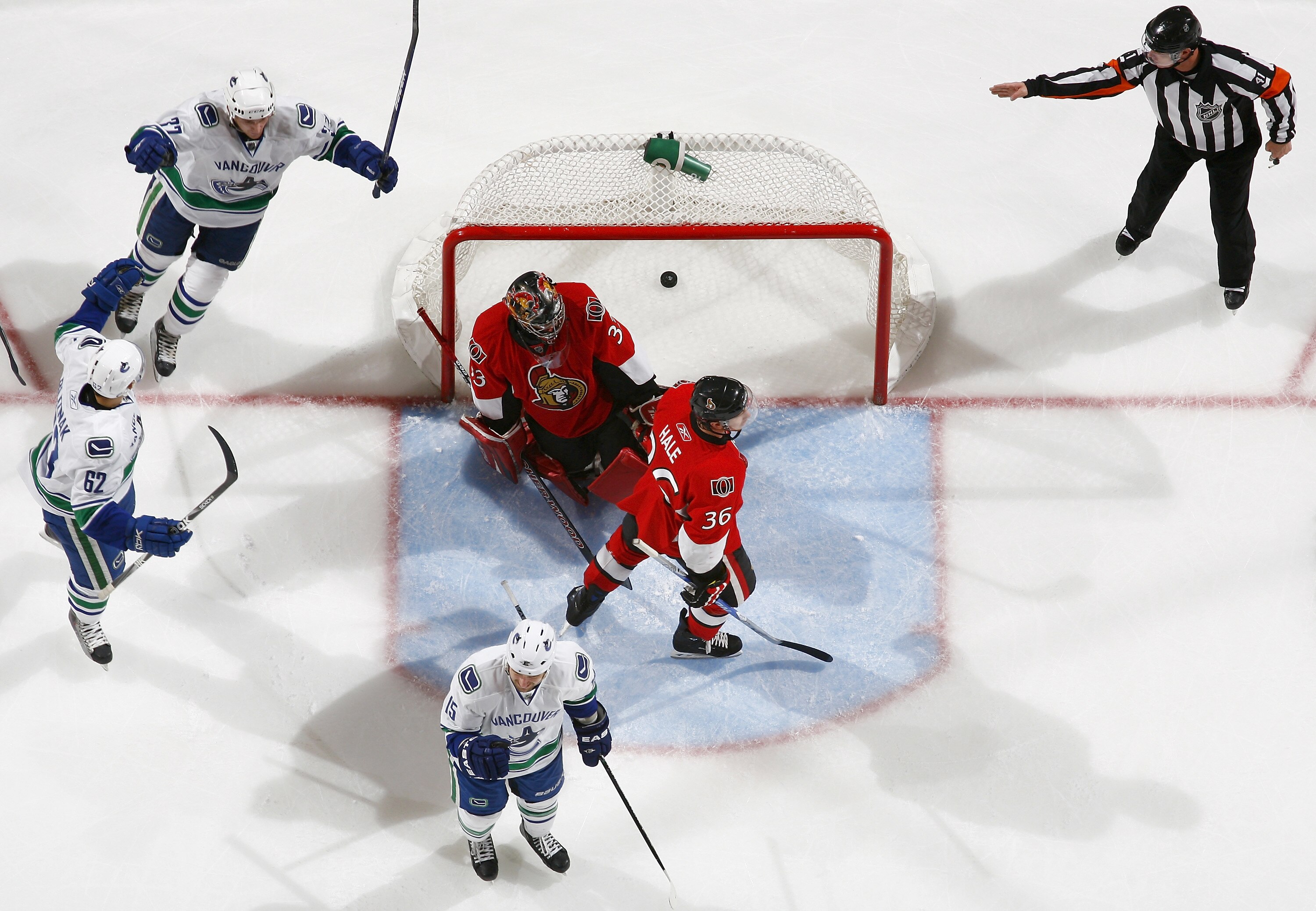 OTTAWA, CANADA - NOVEMBER 11:  Rick Rypien #37;Tanner Glass #15 and Mario Bliznak #62 of the Vancouver Canucks celebrate a goal while Pascal Leclaire #33 and David Hale #36 of the Ottawa Senators look on dejectedly in a game at Scotiabank Place on Novembe