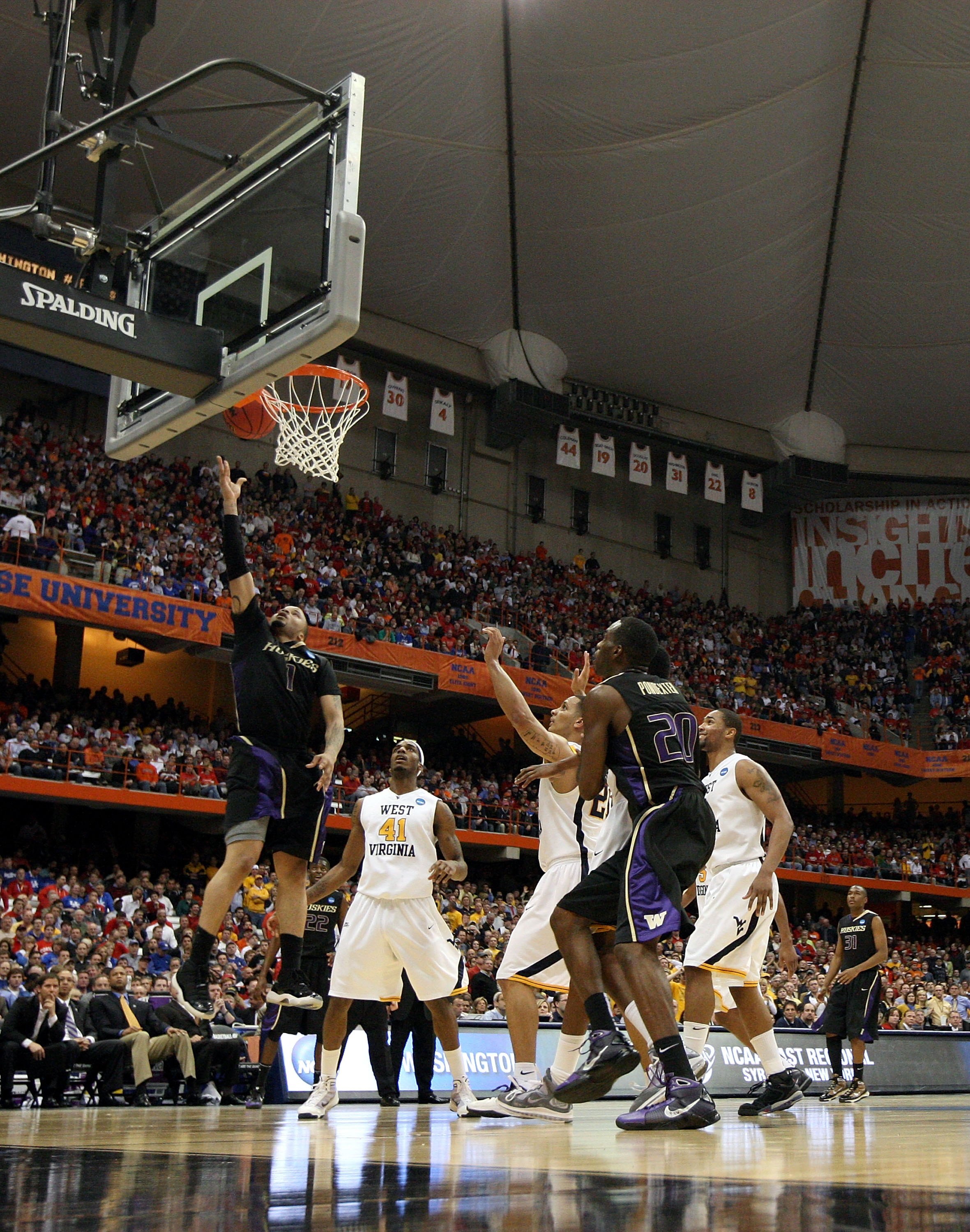 SYRACUSE, NY - MARCH 25: Venoy Overton #1 of the Washington Huskies drives for a shot attempt against John FLowers #41 of the West Virginia Mountaineers during the east regional semifinal of the 2010 NCAA men's basketball tournament at the Carrier Dome o SYRACUSE, NY - MARCH 25: Venoy Overton #1 of the Washington Huskies drives for a shot attempt against John FLowers #41 of the West Virginia Mountaineers during the east regional semifinal of the 2010 NCAA men's basketball tournament at the Carrier Dome o