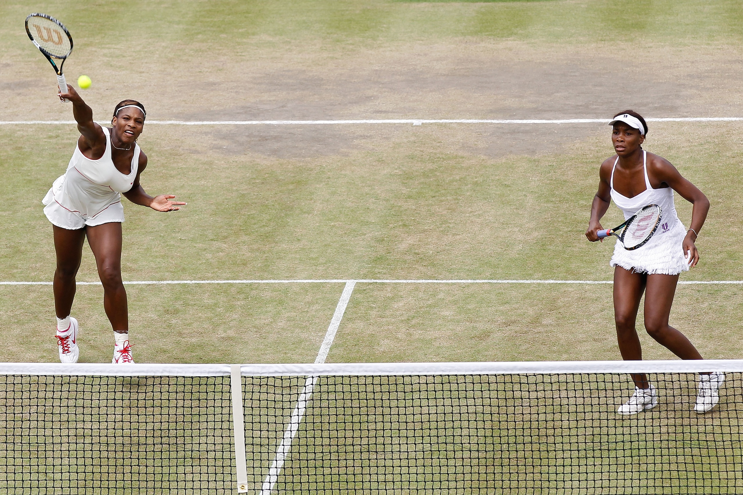 LONDON, ENGLAND - JUNE 30:  Serena Williams (L) and Venus Williams of USA in action during their Quarter Final doubles match against Elena Vesnina and Vera Zvonareva of Russia on Day Nine of the Wimbledon Lawn Tennis Championships at the All England Lawn