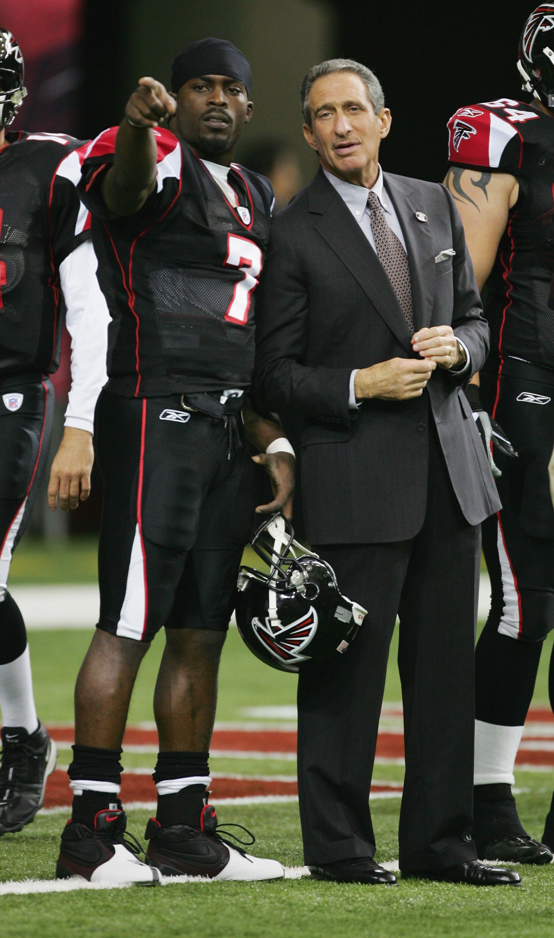ATLANTA - NOVEMBER 28:  Quarterback Michael Vick #7 of the Atlanta Falcons talks with owner Arthur M. Blank prior to the game against the New Orleans Saints at the Georgia Dome on November 28, 2004 in Atlanta, Georgia. The Falcons won 24-21.  (Photo by Sc