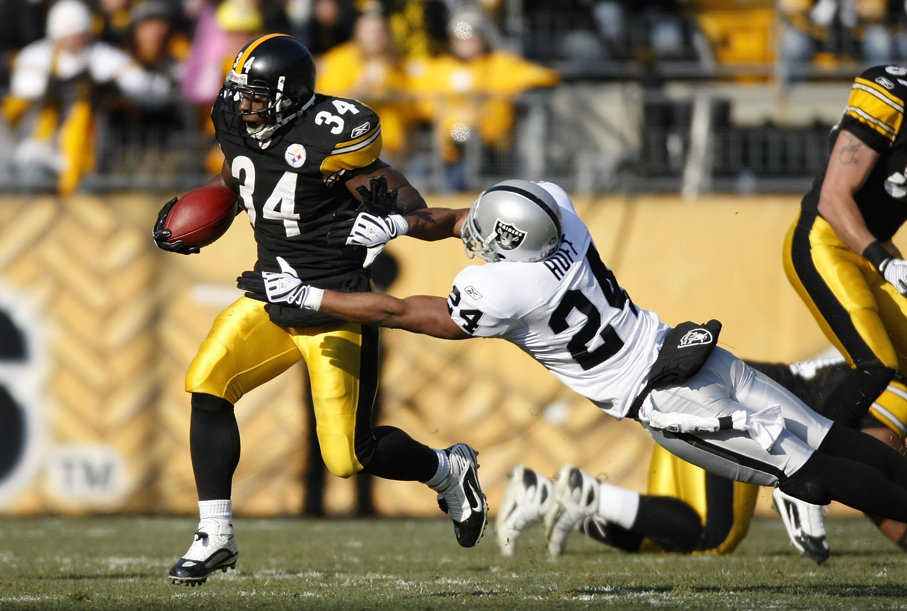 PITTSBURGH - DECEMBER 06:  Rashard Mendenhall #34 of the Pittsburgh Steelers tries to get around the tackle of Michael Huff #24 the Oakland Raiders during a first quarter run on December 6, 2009 at Heinz Field in Pittsburgh, Pennsylvania.  (Photo by Grego