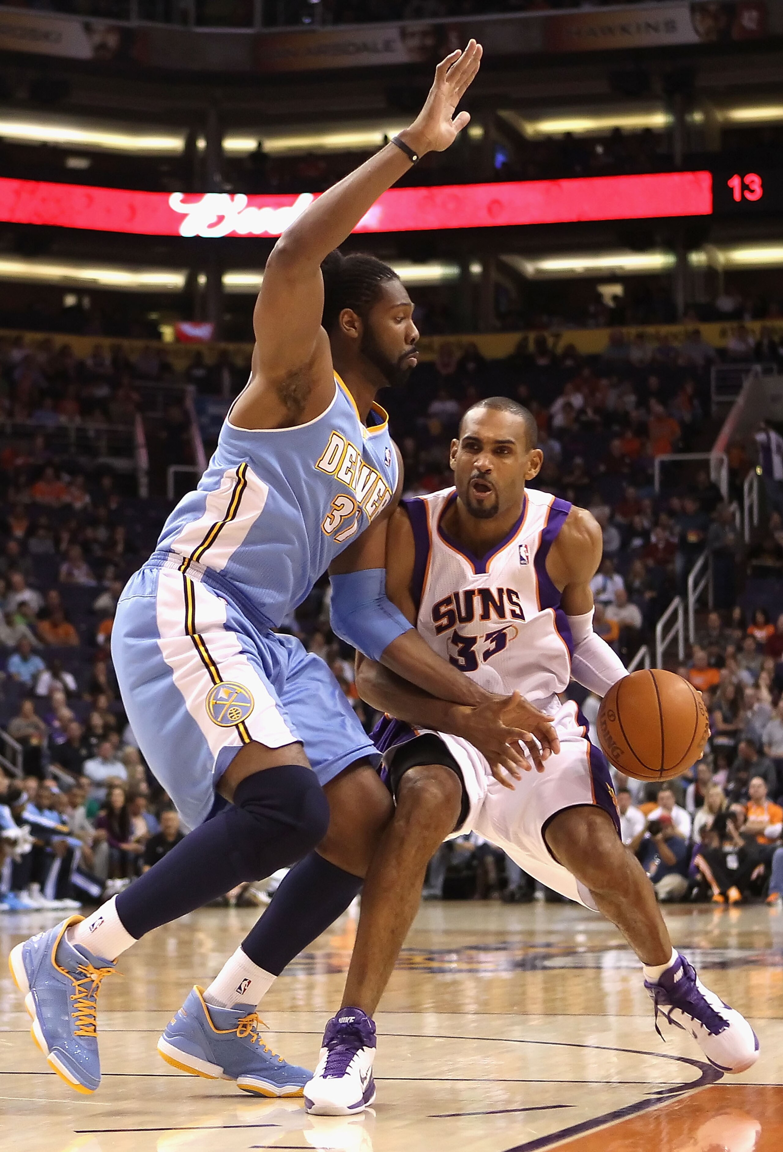 PHOENIX - NOVEMBER 15:  Grant Hill #33 of the Phoenix Suns handles the ball under pressure from Nene of the Denver Nuggets during the NBA game at US Airways Center on November 15, 2010 in Phoenix, Arizona. The Suns defeated the Nuggets 100-94.  NOTE TO US