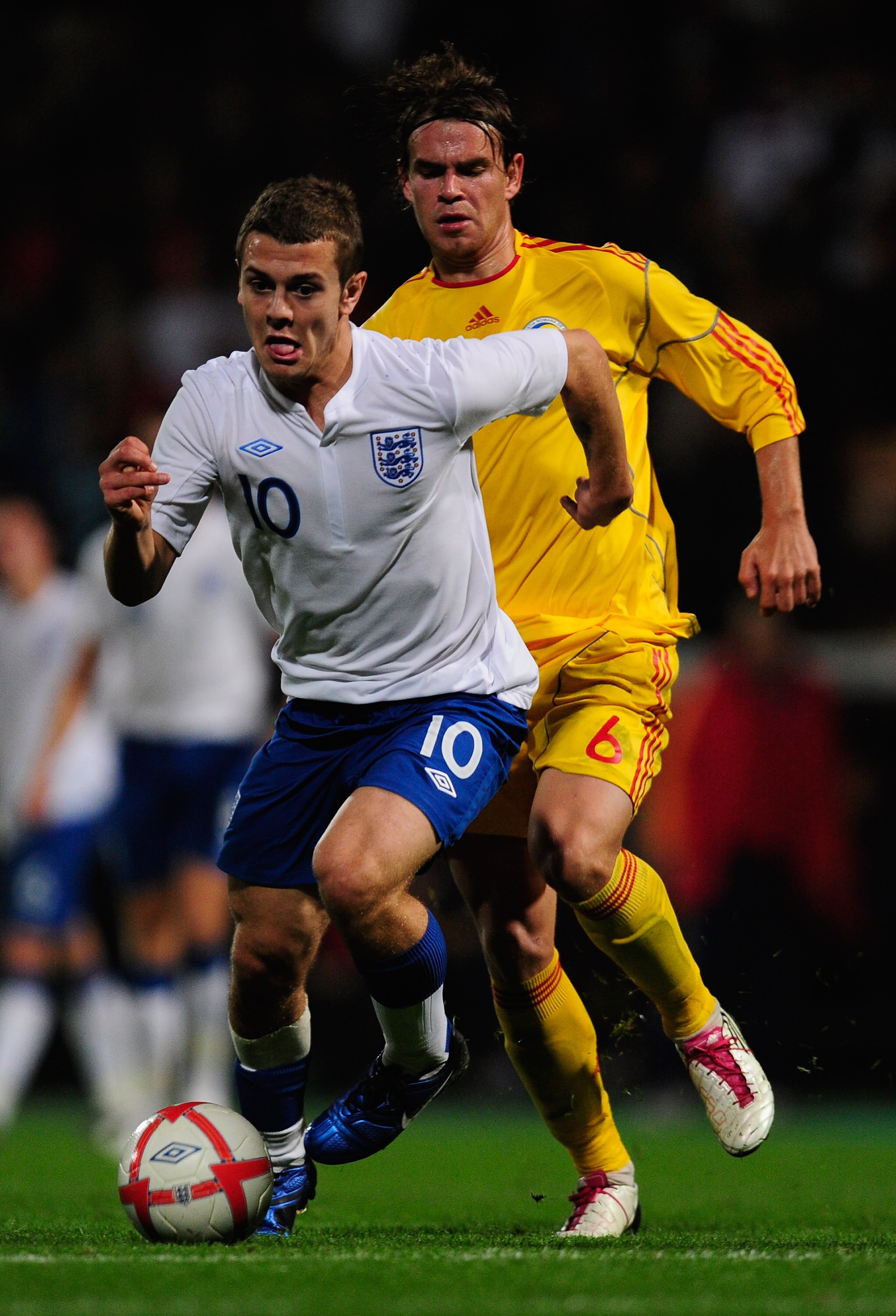 NORWICH, ENGLAND - OCTOBER 08:  Jack Wilshere of England battles with Eric Bicfalvi of Romania during the UEFA U21 Championship Play-Off, First Leg match between England and Romania at Carrow Road on October 8, 2010 in Norwich, England.  (Photo by Jamie M