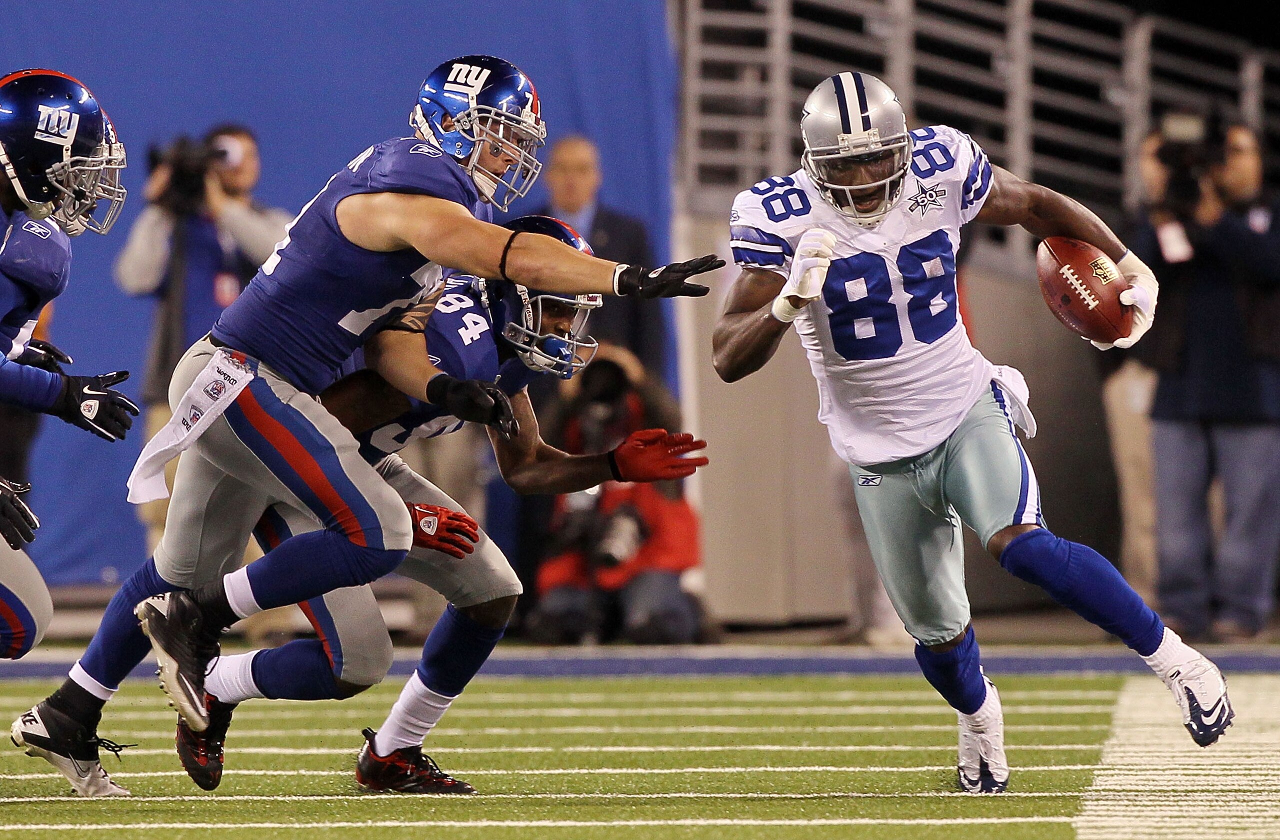 EAST RUTHERFORD, NJ - NOVEMBER 14:  Dez Bryant #88 of the Dallas Cowboys runs a kick off past Dave Tollefson #71, and Duke Calhoun #84 of the New York Giants on November 14, 2010 at the New Meadowlands Stadium in East Rutherford, New Jersey.  (Photo by Ji
