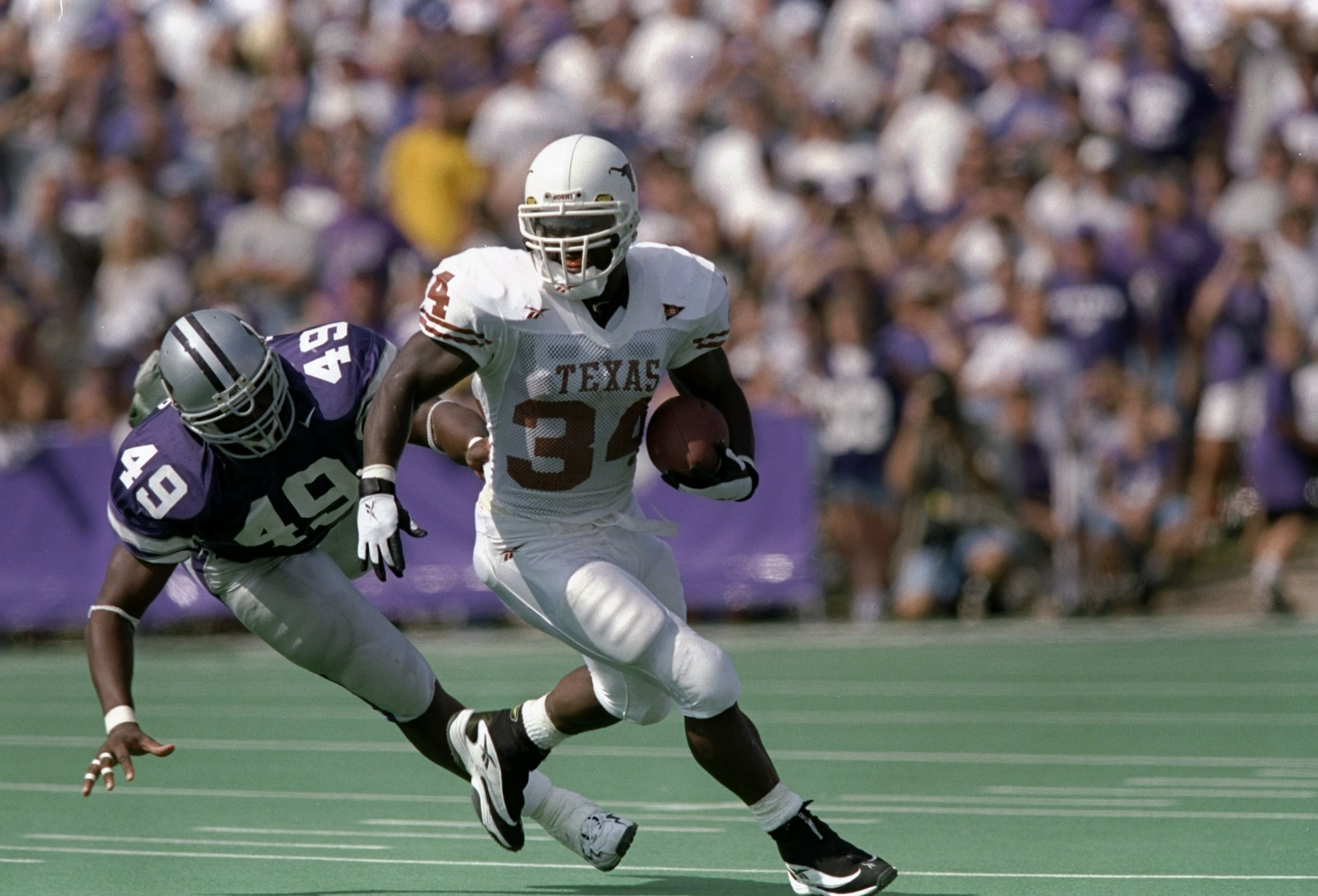 19 Sep 1998: Tailback Ricky Williams #34 of the Texas Longhorns runs with the ball while being pursued by Darren Howard #49 of the Kansas State Wildcats during a game at the KSU Wagner Field in Manhattan, Kansas. The Wildcats defeated the Longhorns 48-7. 19 Sep 1998: Tailback Ricky Williams #34 of the Texas Longhorns runs with the ball while being pursued by Darren Howard #49 of the Kansas State Wildcats during a game at the KSU Wagner Field in Manhattan, Kansas. The Wildcats defeated the Longhorns 48-7.