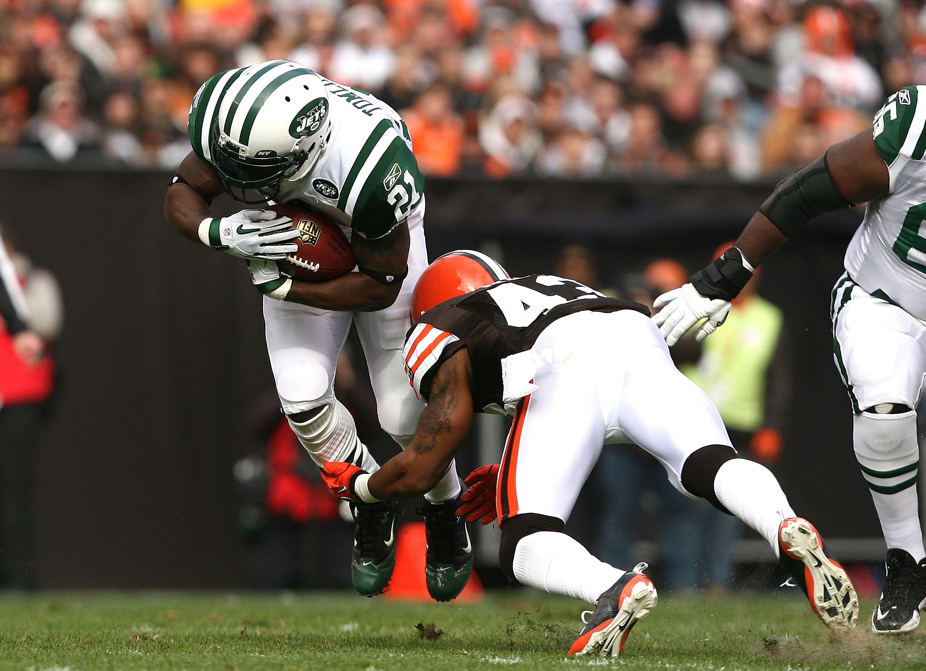 CLEVELAND - NOVEMBER 14:  Running back LaDainian Tomlinson #21 of the New York Jets is hit by defensive back T.J. Ward #43  of the Cleveland Browns  at Cleveland Browns Stadium on November 14, 2010 in Cleveland, Ohio.  (Photo by Matt Sullivan/Getty Images