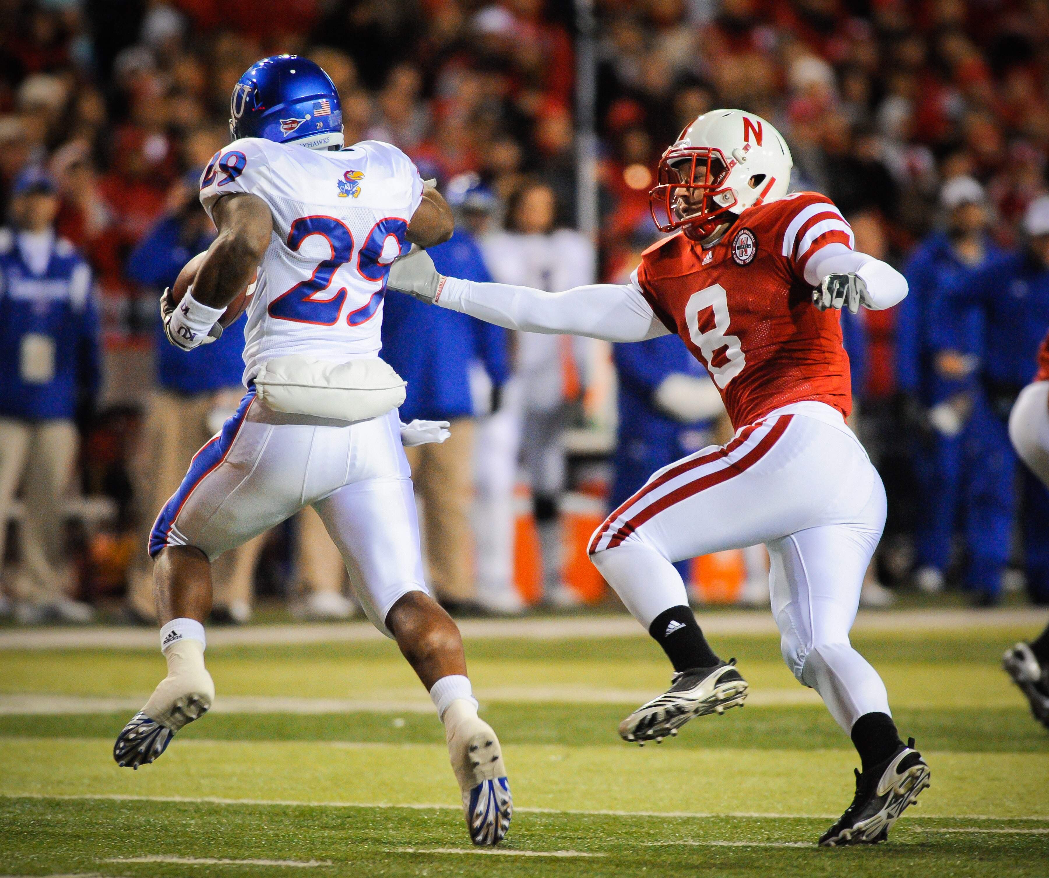 LINCOLN, NE - NOVEMBER 13: Austin Cassidy #8 of the Nebraska Cornhuskers tries to wrangle James Sims #29 of the Kansas Jayhawks during second half action of their game at Memorial Stadium on November 13, 2010 in Lincoln, Nebraska. Nebraska Defeated Kansas