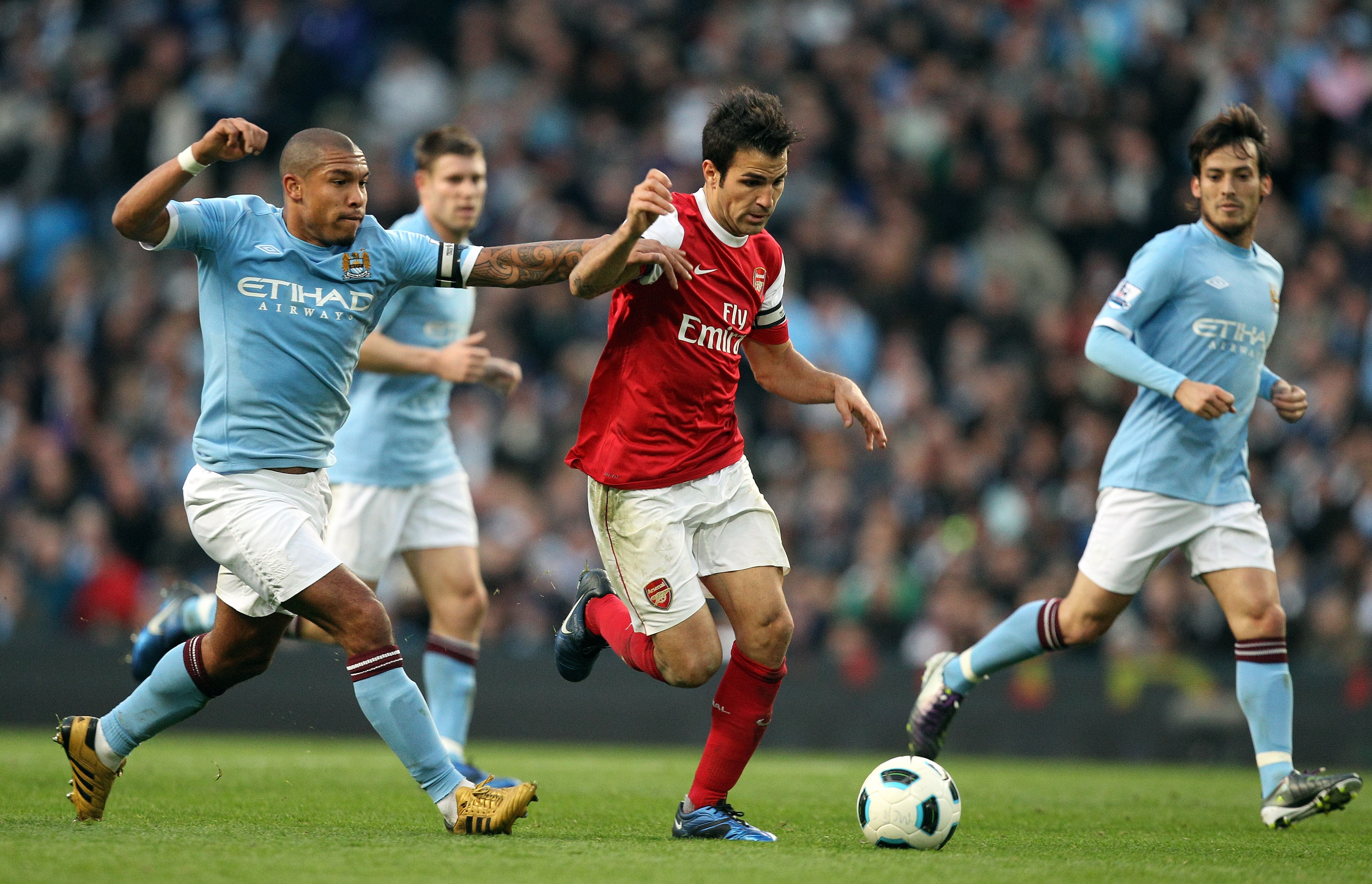 MANCHESTER, ENGLAND - OCTOBER 24:  Cesc Fabregas of Arsenal holds off Nigel De Jong of City during the Barclays Premier League match between Manchester City and Arsenal at City of Manchester Stadium on October 24, 2010 in Manchester, England.  (Photo by R