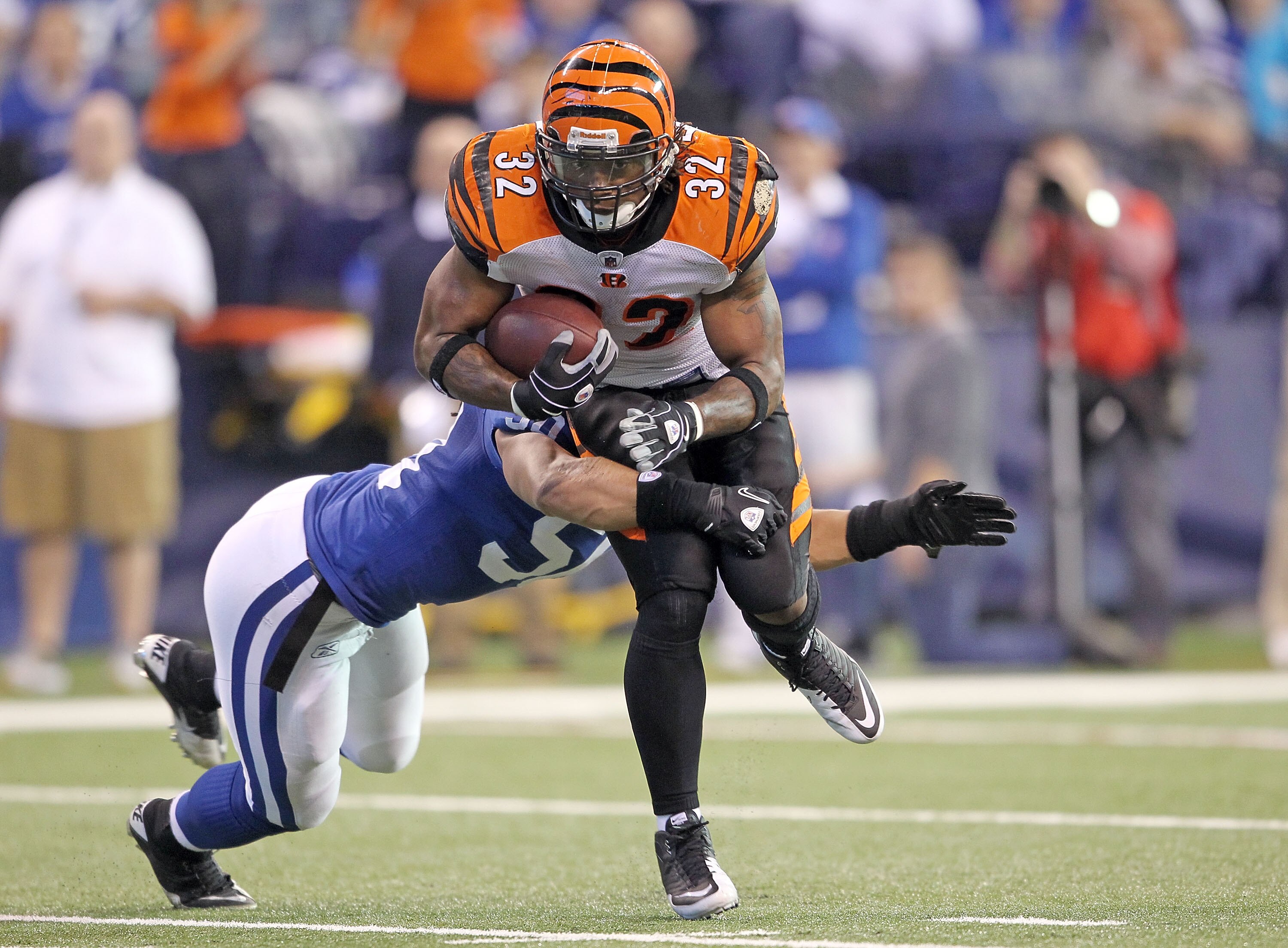 INDIANAPOLIS - NOVEMBER 14:  Cedric Benson #32 of the Cincinnati Bengals runs with the ball while defended by Phillip Wheeler #50 of the Indianapolis Colts during the NFL game at Lucas Oil Stadium on November 14, 2010 in Indianapolis, Indiana.  (Photo by