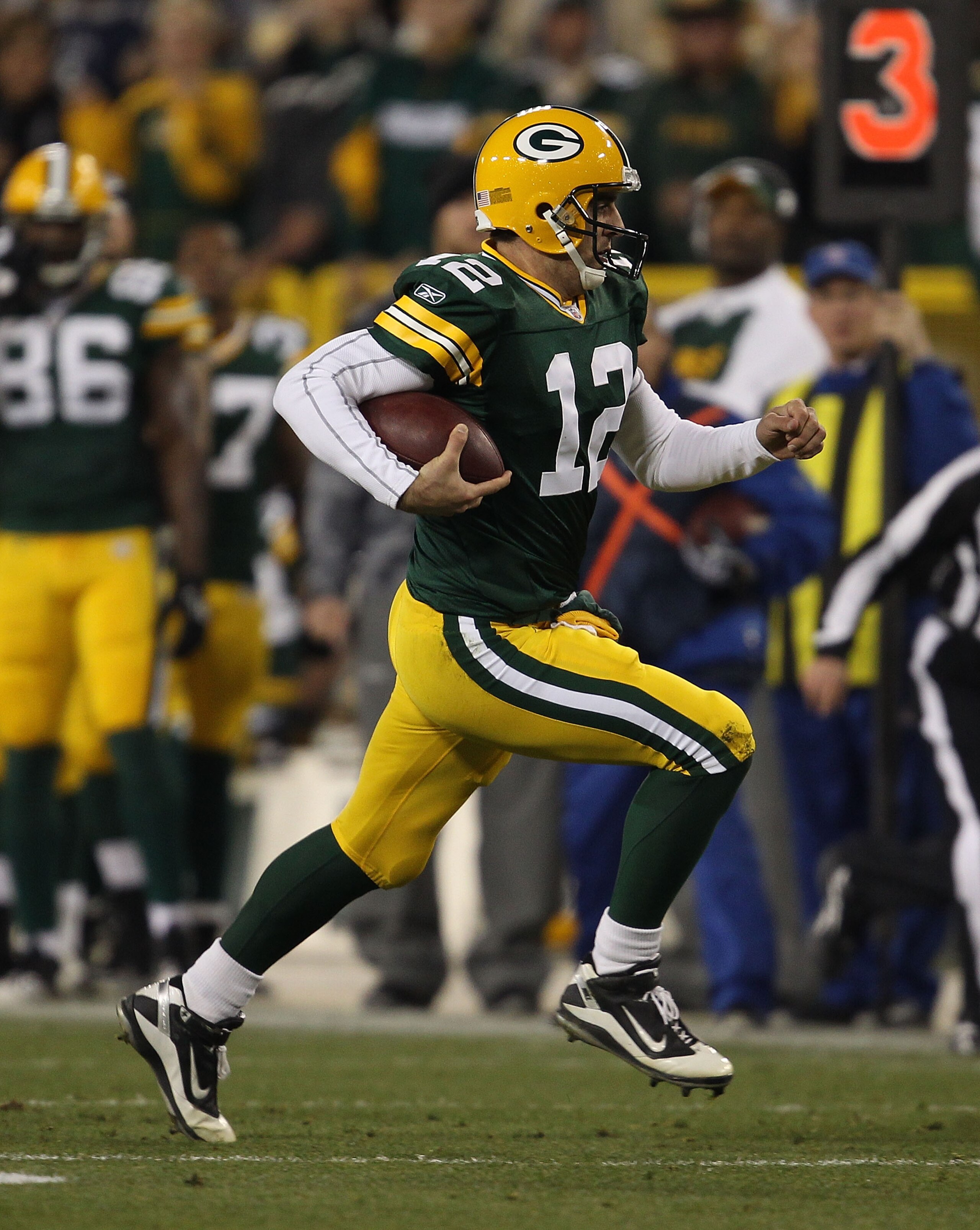 GREEN BAY, WI - NOVEMBER 07: Aaron Rodgers #12 of the Green Bay Packers runs for a first down against the Dallas Cowboys at Lambeau Field on November 7, 2010 in Green Bay, Wisconsin. The Packers defeated the Cowboys 45-7. (Photo by Jonathan Daniel/Getty I