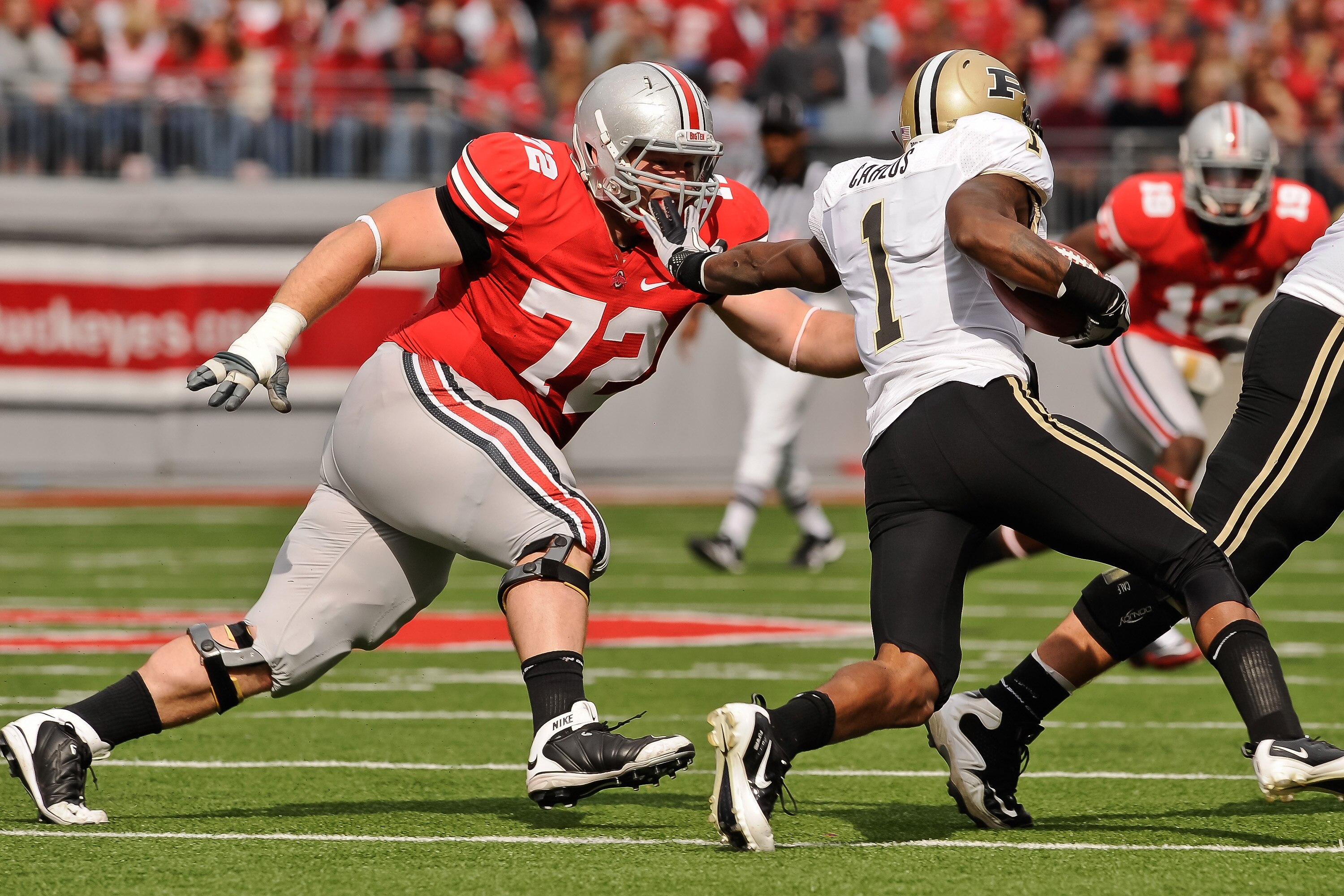 COLUMBUS, OH - OCTOBER 23:  Dexter Larimore #72 of the Ohio State Buckeyes attempts to tackle Keith Carlos #1 of the Purdue Boilermakers at Ohio Stadium on October 23, 2010 in Columbus, Ohio.  (Photo by Jamie Sabau/Getty Images)
