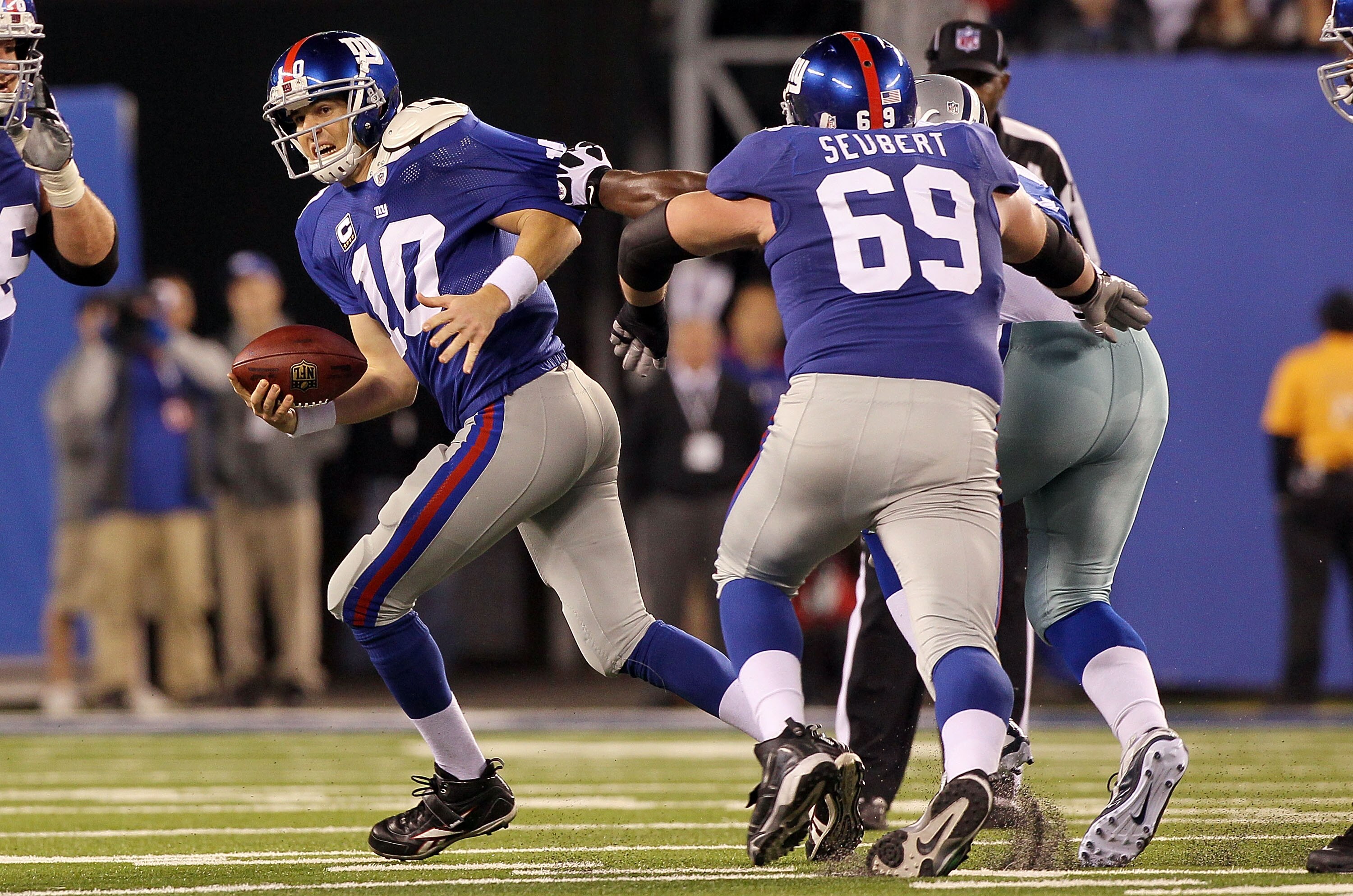 EAST RUTHERFORD, NJ - NOVEMBER 14:  Eli Manning #10 of the New York Giants tries to run the ball against the Dallas Cowboys on November 14, 2010 at the New Meadowlands Stadium in East Rutherford, New Jersey. The Cowboys defeated the Giants 33-20.  (Photo 