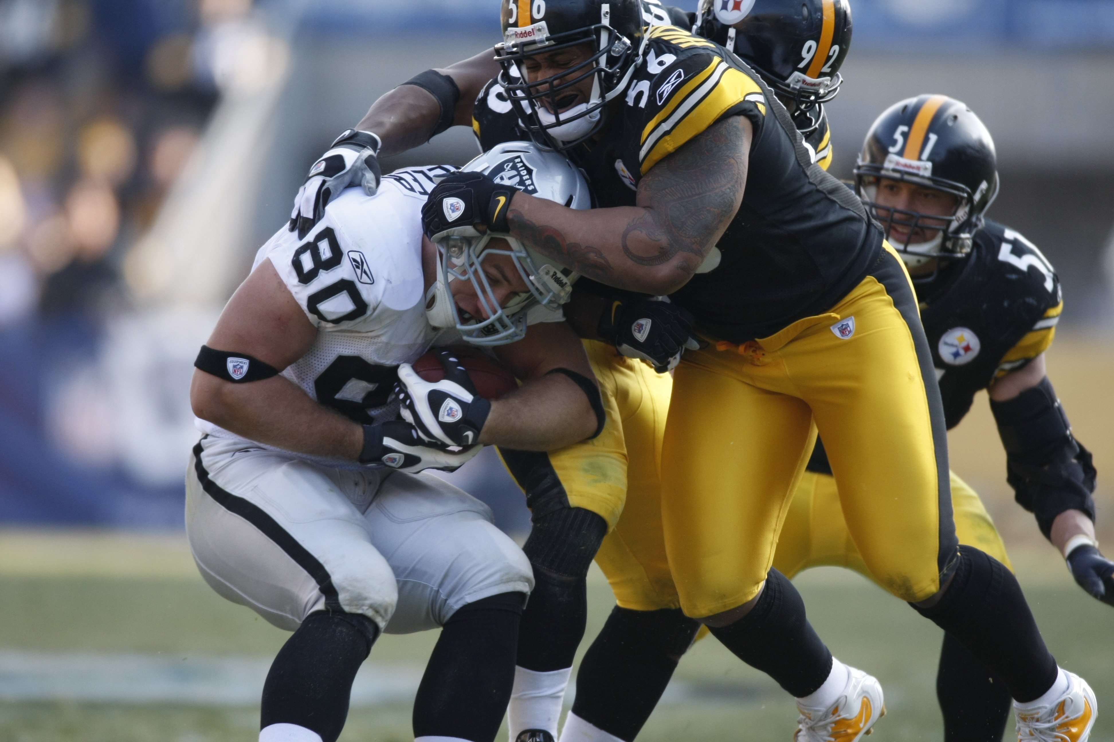 PITTSBURGH - DECEMBER 06:  LaMarr Woodley #56 of the Pittsburgh Steelers tackles Zach Miller #80 of the Oakland Raiders on December 6, 2009 at Heinz Field in Pittsburgh, Pennsylvania.  (Photo by Gregory Shamus/Getty Images)