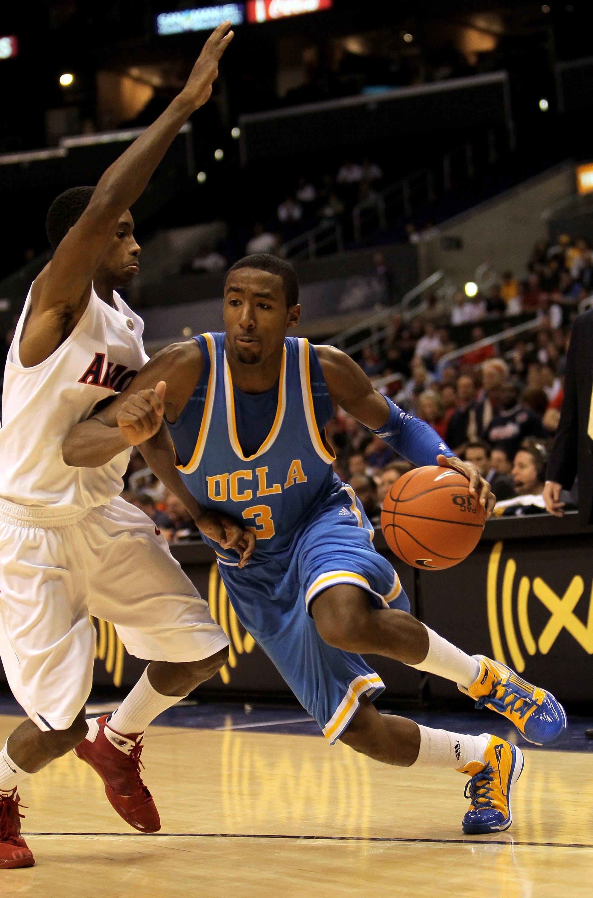 LOS ANGELES, CA - MARCH 11:  Malcolm Lee #3 of the UCLA Bruins drives arouund Kyle Fogg #21 of the Arizona Wildcats during the quarterfinals of the Pac-10 Basketball Tournament at Staples Center on March 11, 2010 in Los Angeles, California. UCLA won 75-69