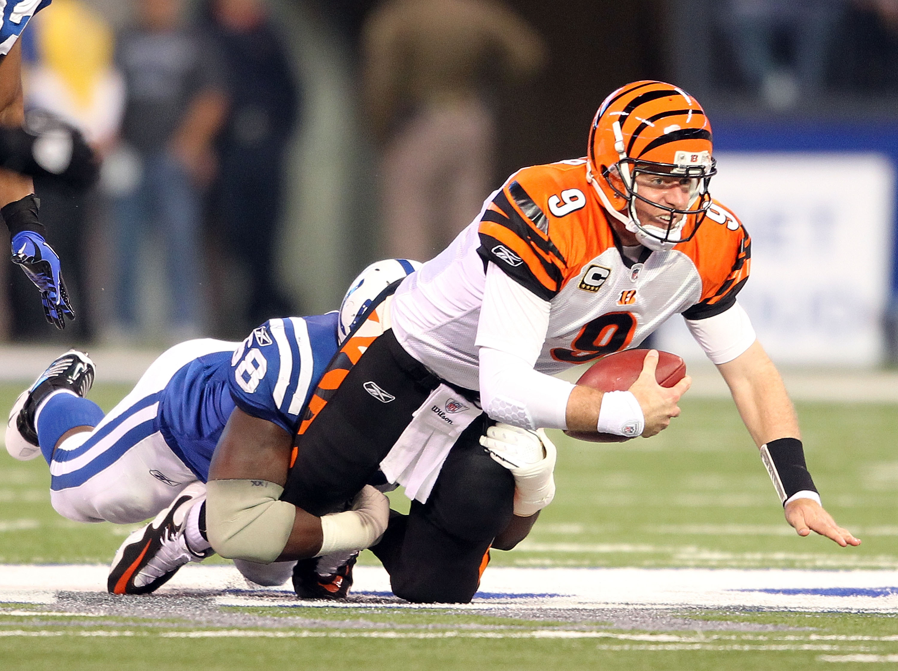 INDIANAPOLIS - NOVEMBER 14:  Carson Palmer #9 of the Cincinnati Bengals is sacked by Eric Foster #68 of the Indianapolis Colts during the NFL game at Lucas Oil Stadium on November 14, 2010 in Indianapolis, Indiana. The Colts won 23-17.  (Photo by Andy Lyo