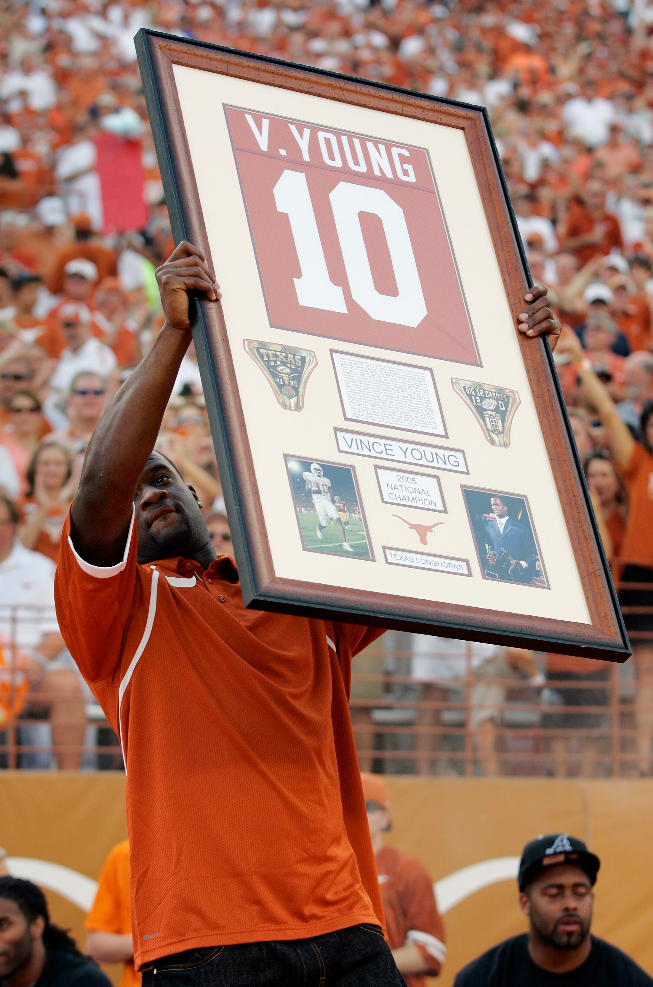 AUSTIN, TX - AUGUST 30:  Quarterback Vince Young of the Tennessee Titans, holds up his Texas Longhorns jersey as his number is retired before a game against the Florida Atlantic Owls at Darrell K Royal-Texas Memorial Stadium on August 30, 2007 in Austin,