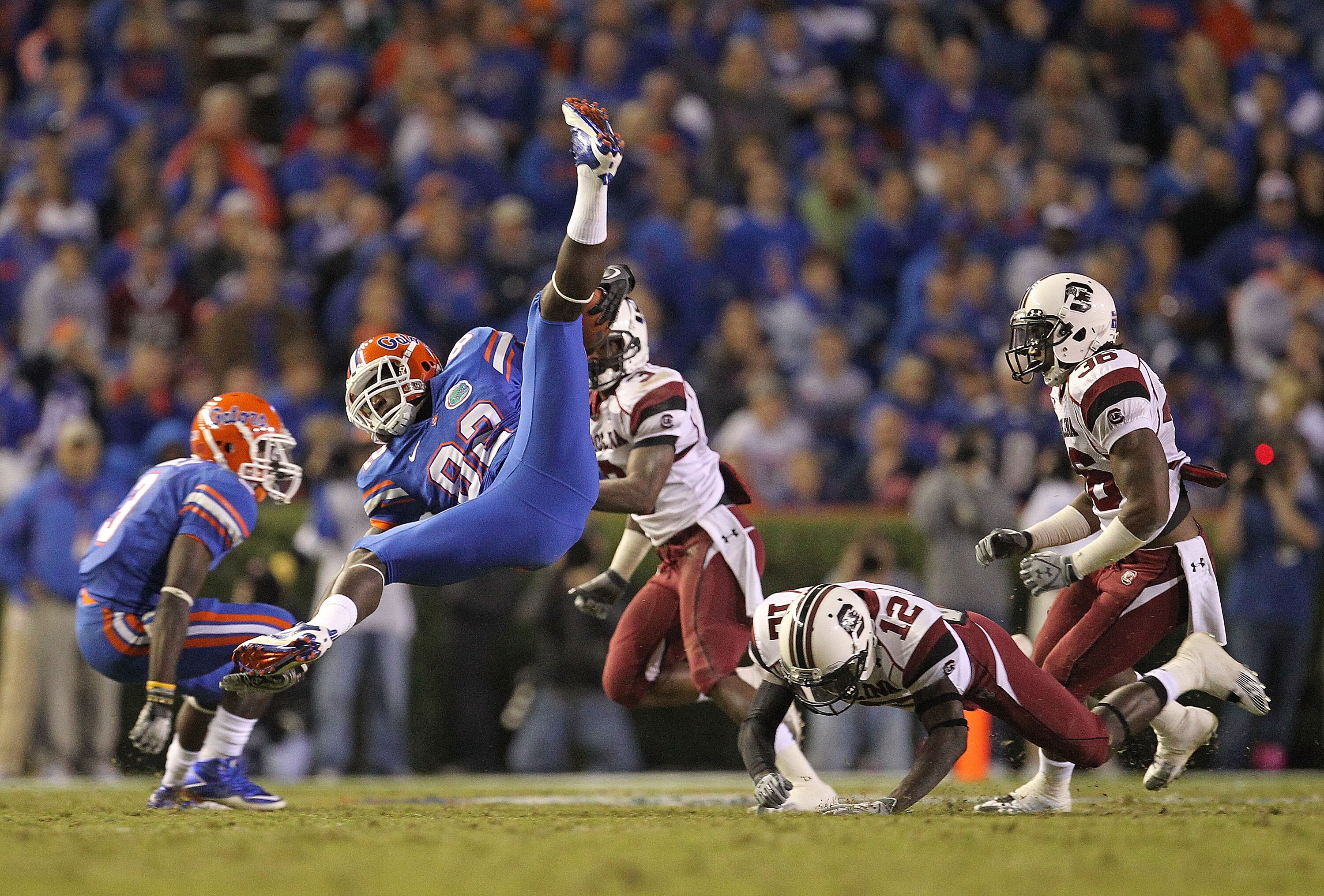 GAINESVILLE, FL - NOVEMBER 13: D.L. Moore #82 of the Florida Gators is upended after a catch by C.C. Whitlock #12 of the South Carolina Gamecocks during a game at Ben Hill Griffin Stadium on November 13, 2010 in Gainesville, Florida.  (Photo by Mike Ehrma