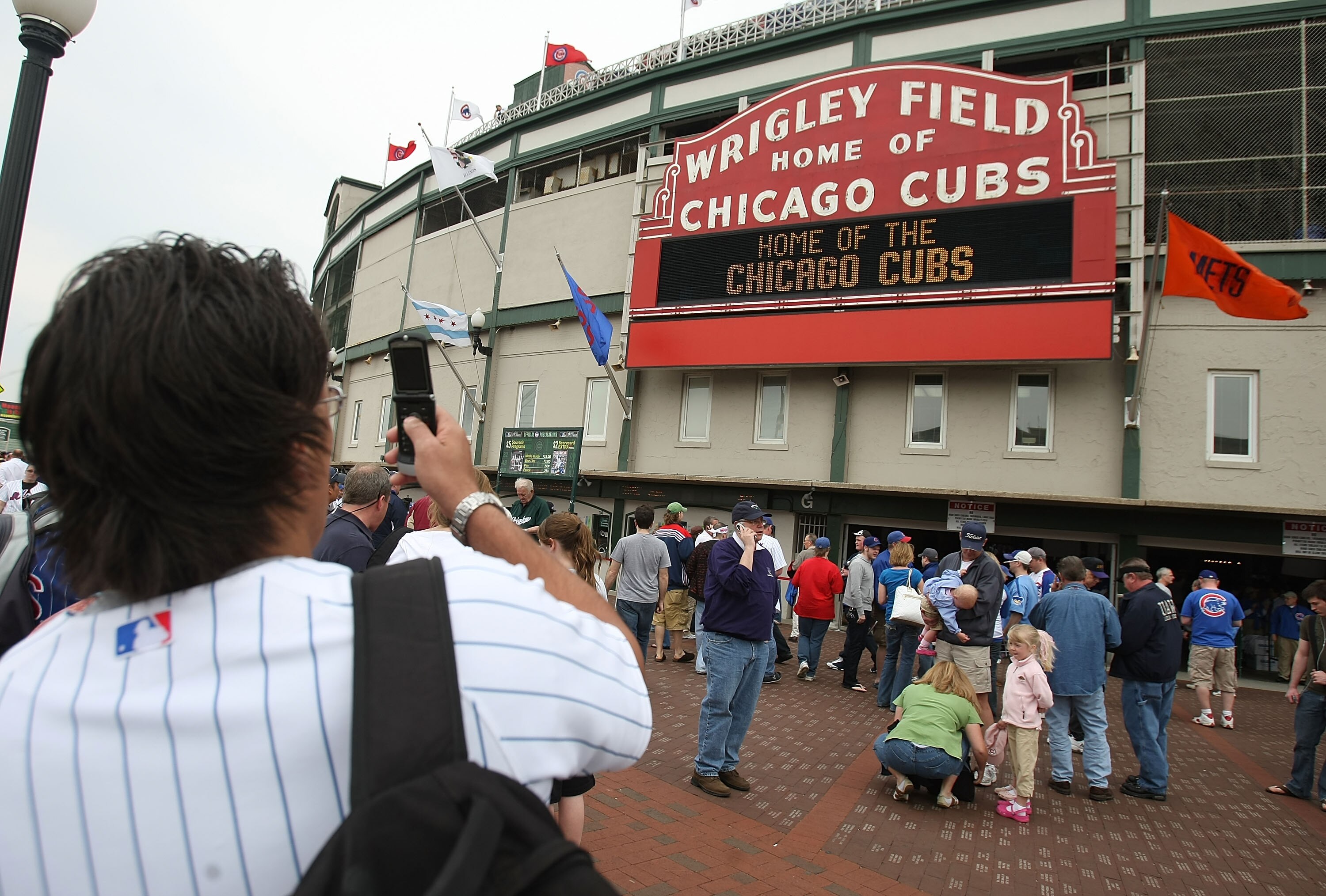 CHICAGO - APRIL 22: A fan takes a photograph with his cell phone outside of Wrigley Field before the Chicago Cubs take on  the New York Mets on April 22, 2008 in Chicago, Illinois. (Photo by Jonathan Daniel/Getty Images)