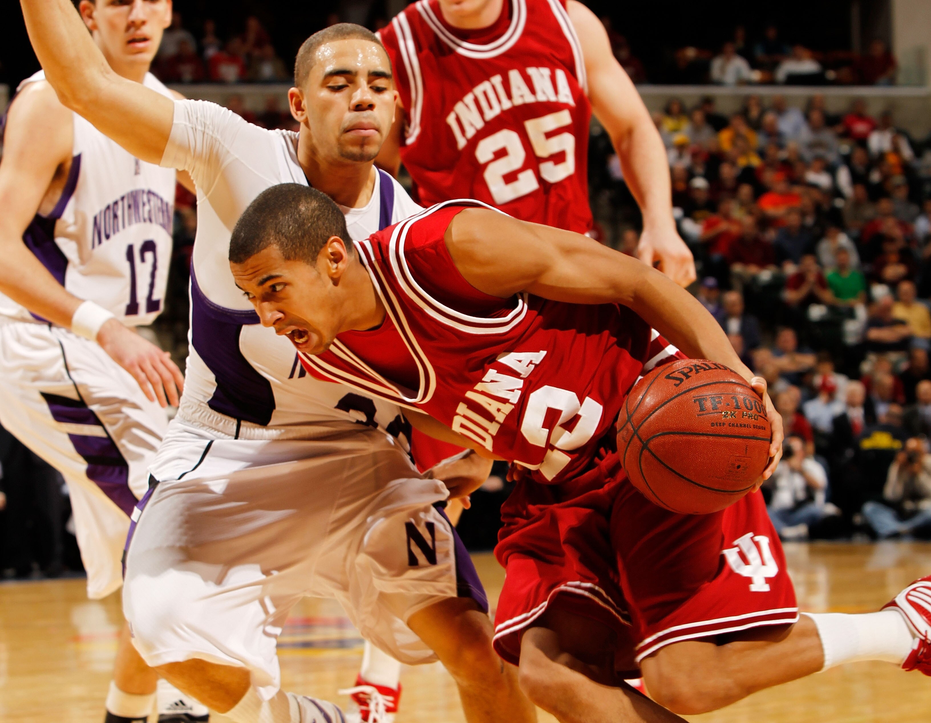 INDIANAPOLIS - MARCH 11:  Guard Verdell Jones III #12 of the Indiana Hoosiers drives with the ball against guard Michael Thompson #22 of the Northwestern Wildcats during the first round of the Big Ten Men's Basketball Tournament at Conseco Fieldhouse on M
