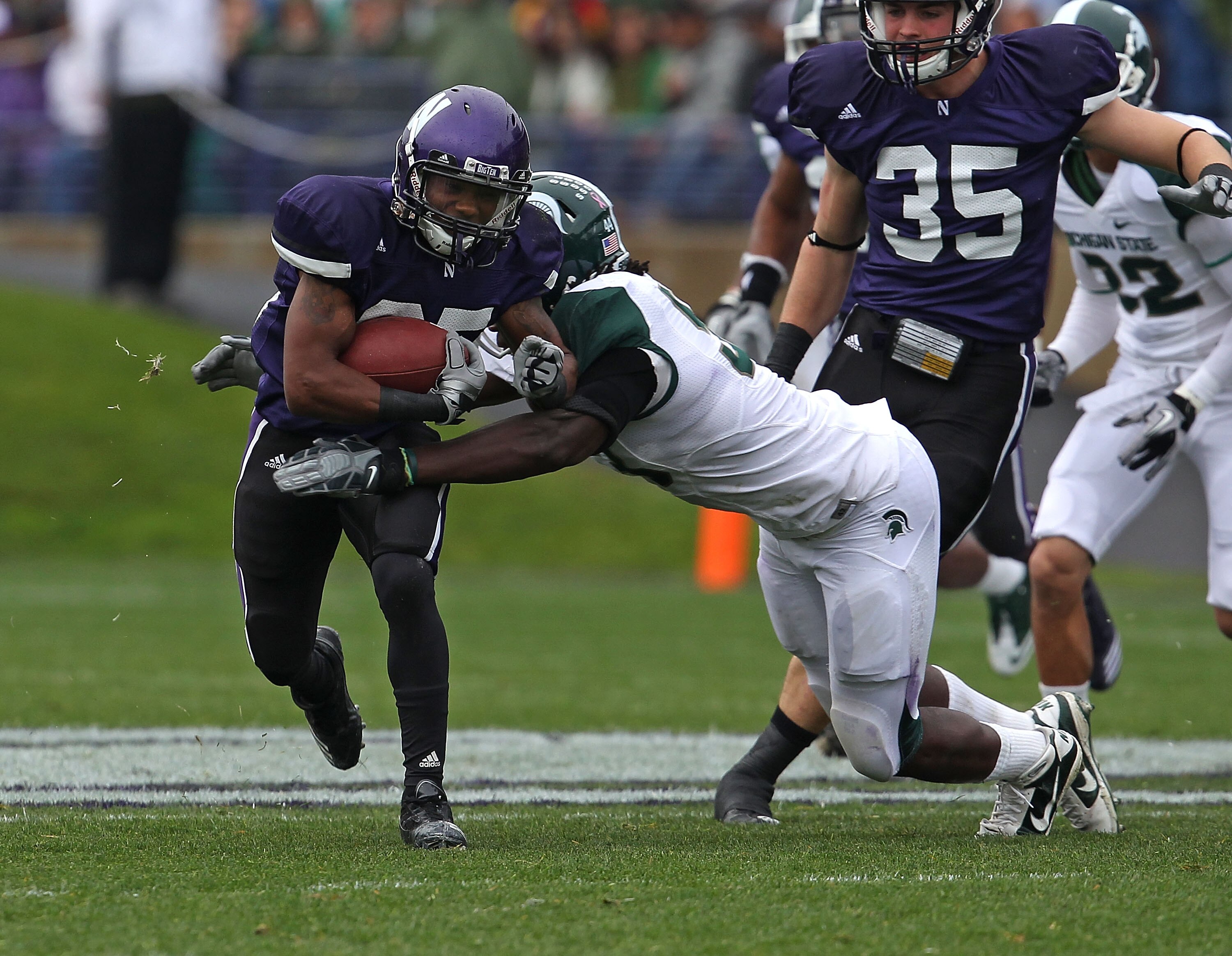 EVANSTON, IL - OCTOBER 23: Venric Mark #85 of the Northwestern Wildcats is hit by Eric Jones #53 of the Michigan State Spartans at Ryan Field on October 23, 2010 in Evanston, Illinois. Michigan State defeated Northwestern 35-27. (Photo by Jonathan Daniel/