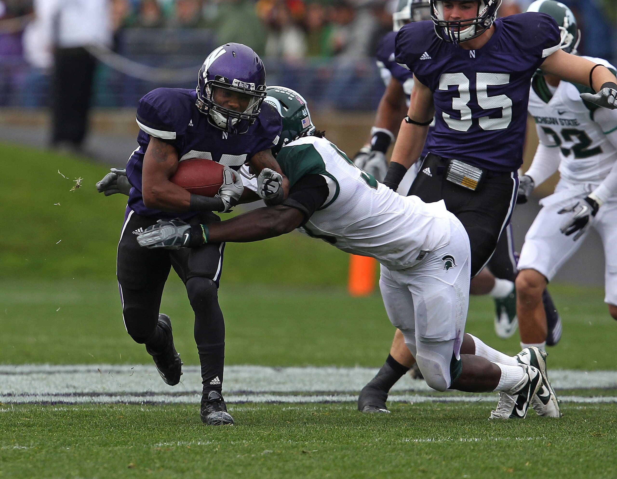 EVANSTON, IL - OCTOBER 23: Venric Mark #85 of the Northwestern Wildcats is hit by Eric Jones #53 of the Michigan State Spartans at Ryan Field on October 23, 2010 in Evanston, Illinois. Michigan State defeated Northwestern 35-27. (Photo by Jonathan Daniel/