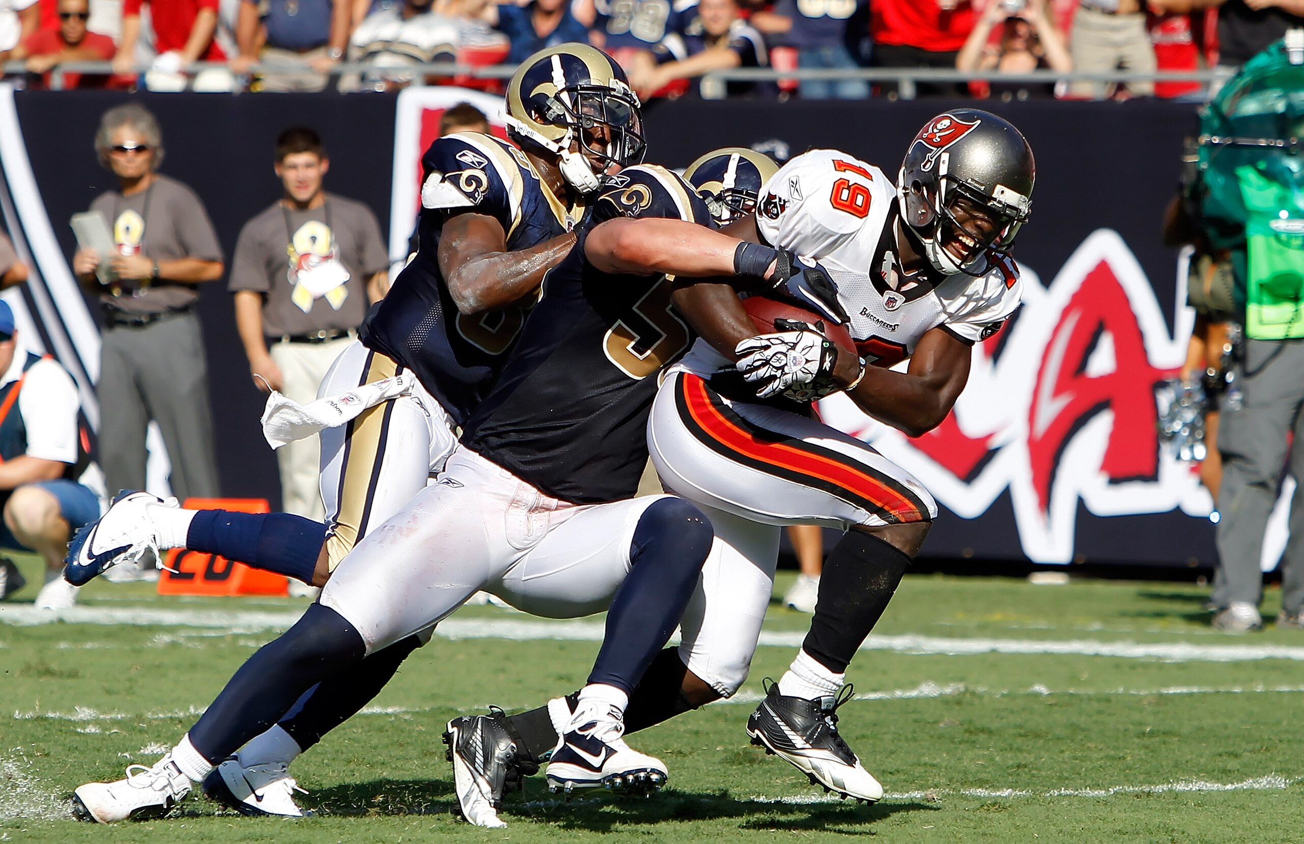 TAMPA, FL - OCTOBER 24:  Defenders Kevin Dockery #35 and James Laurinaitis #55 of the St. Louis Rams bring down receiver Mike Williams #19 of the Tampa Bay Buccaneers during the game at Raymond James Stadium on October 24, 2010 in Tampa, Florida.  (Photo