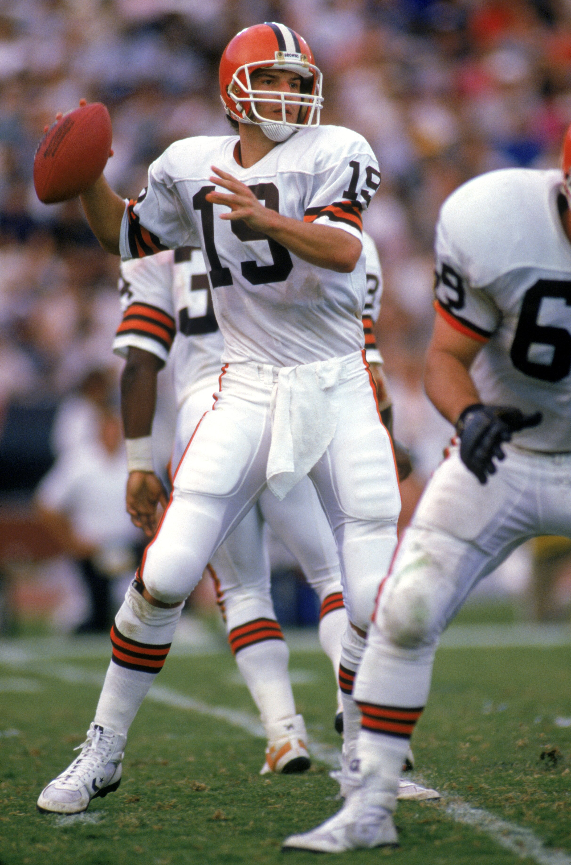 LOS ANGELES - NOVEMBER 16:  Quarterback Bernie Kosar #19 of the Cleveland Browns looks for a receiver during a game against the Los Angeles Raiders at the Los Angeles Memorial Coliseum on November 16, 1986 in Los Angeles, California.  The Raiders won 27-1